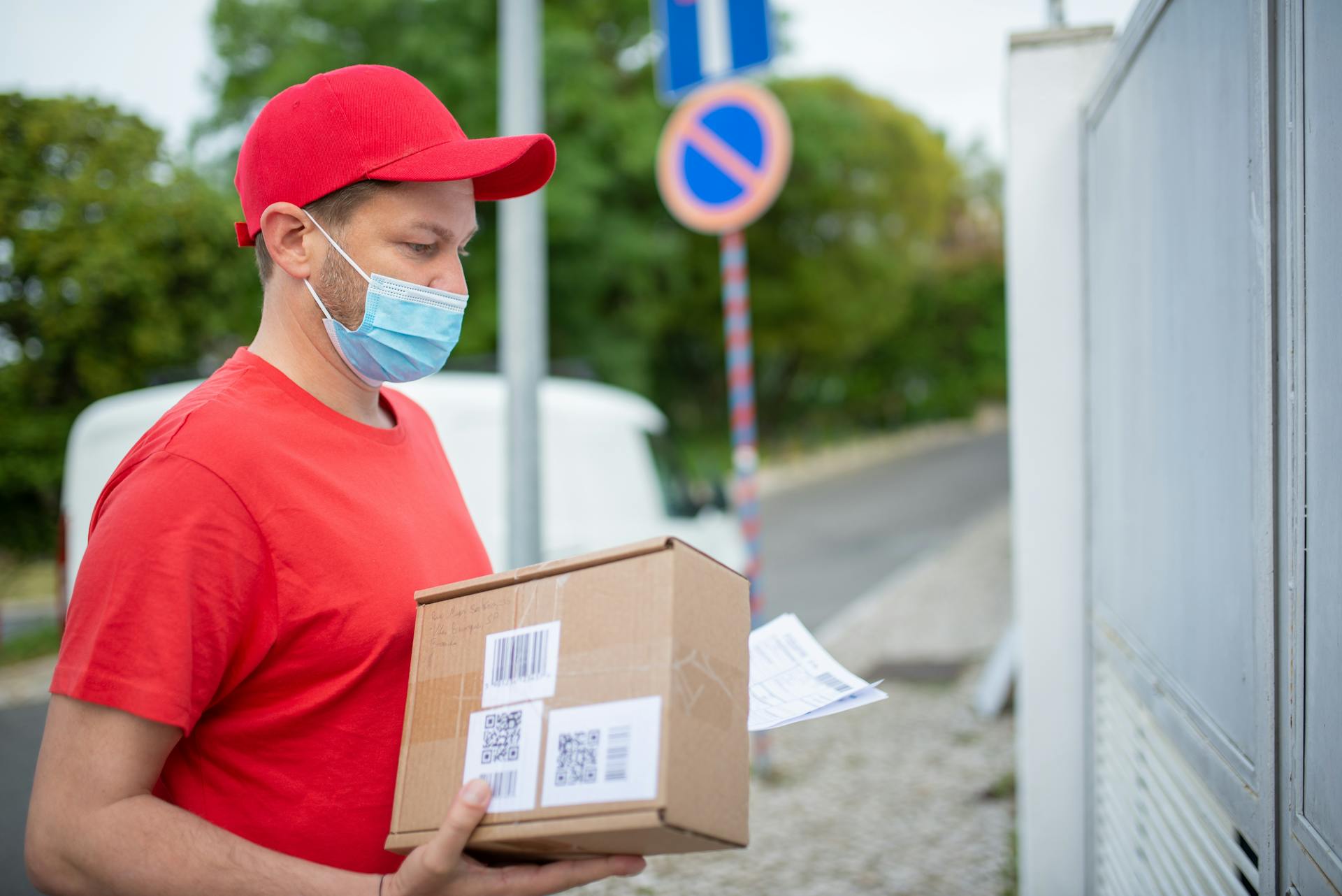 A delivery man holding a parcel | Source: Pexels