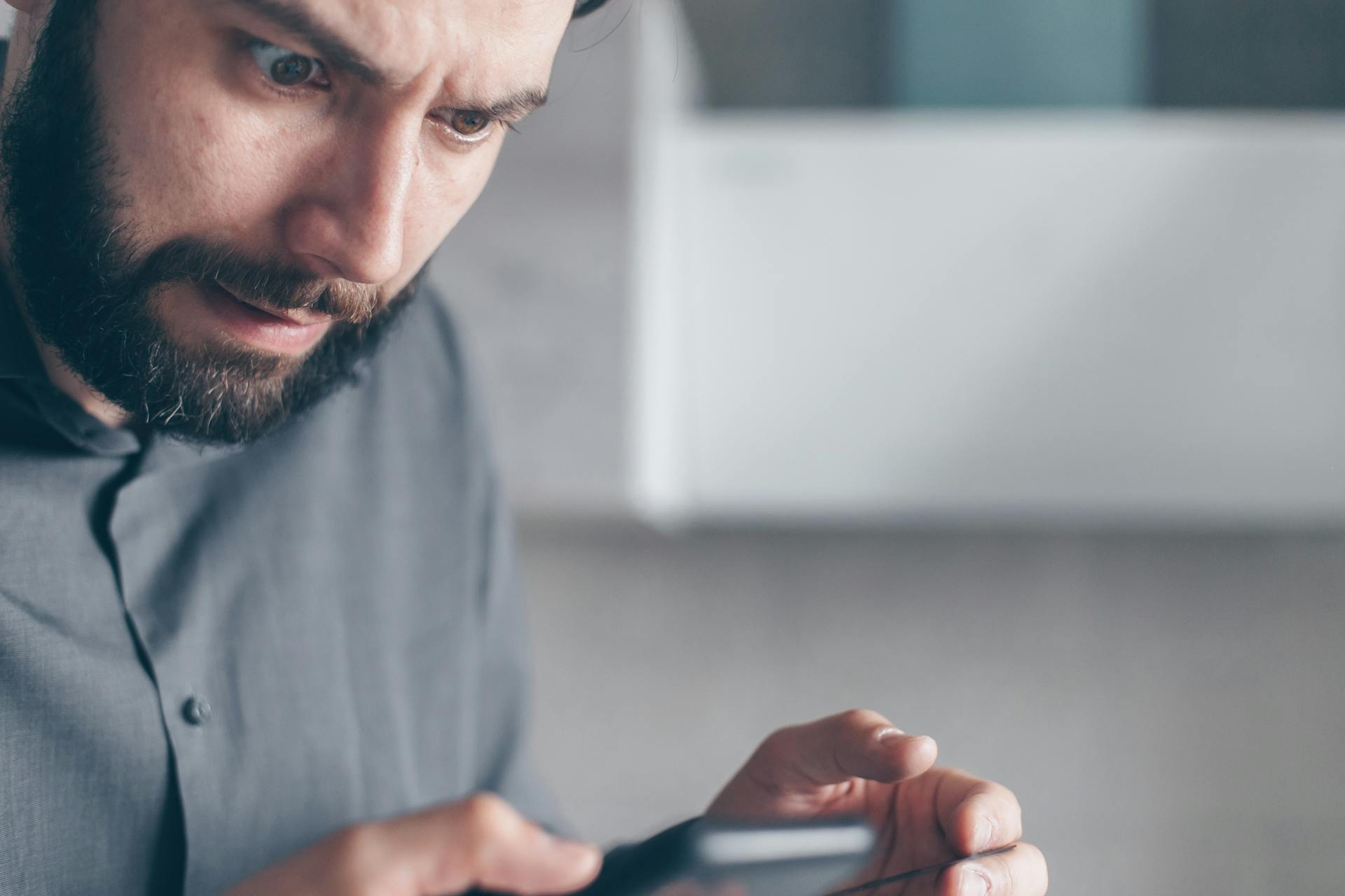 A man staring at his phone in horror | Source: Pexels