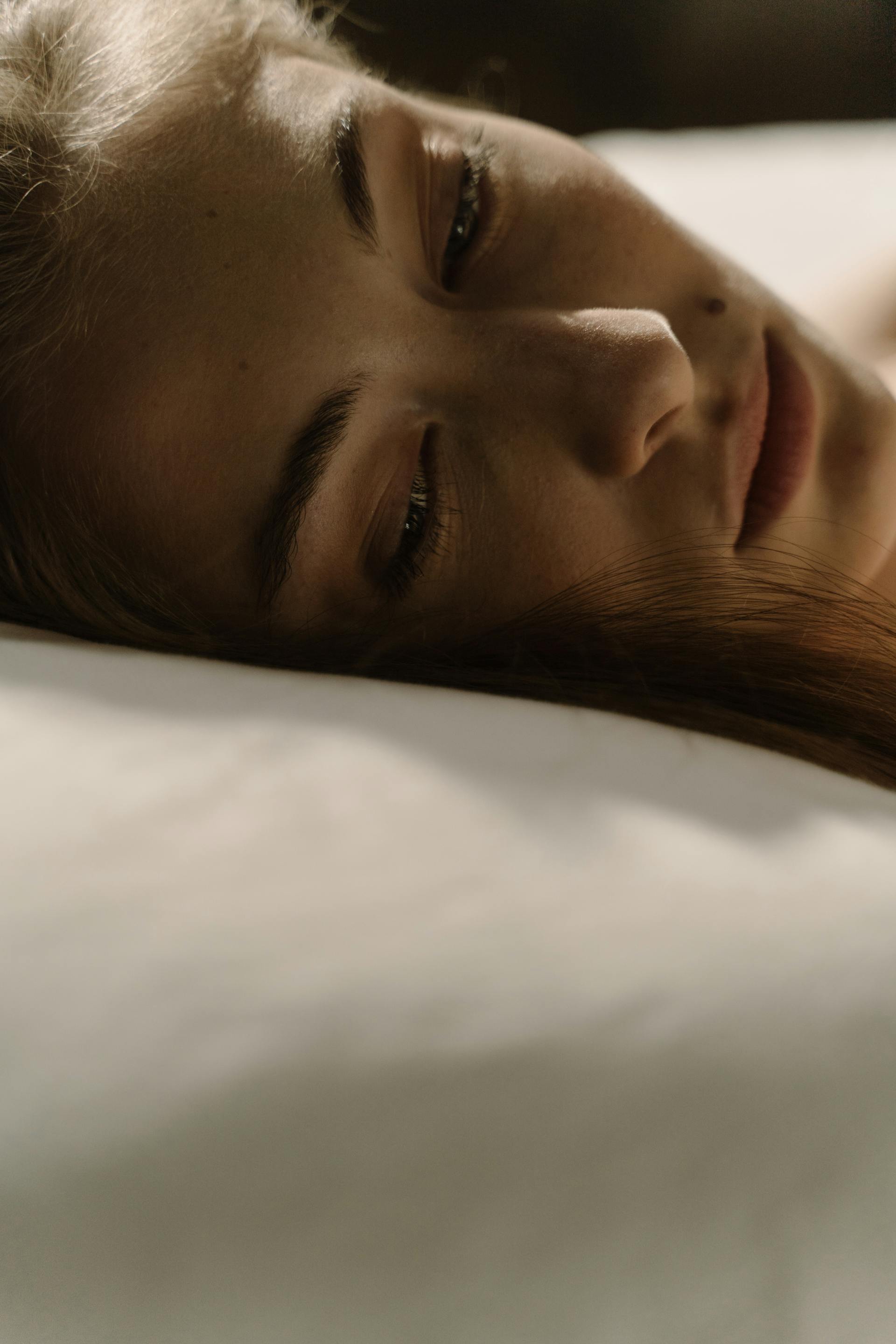 A close-up shot of a woman lying awake in bed | Source: Pexels