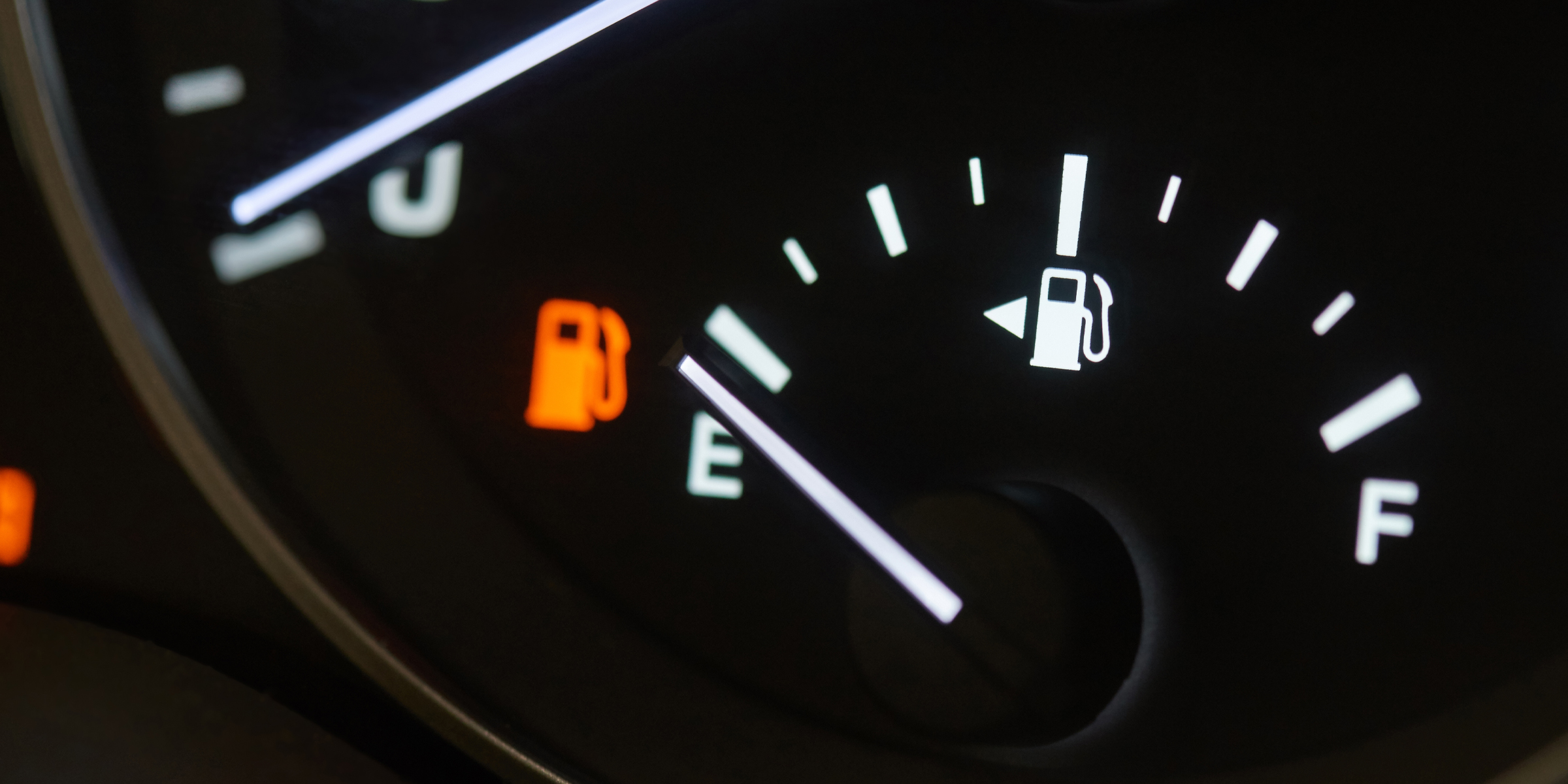 Car fuel gauge showing empty with low-fuel warning light on | Source: Shutterstock