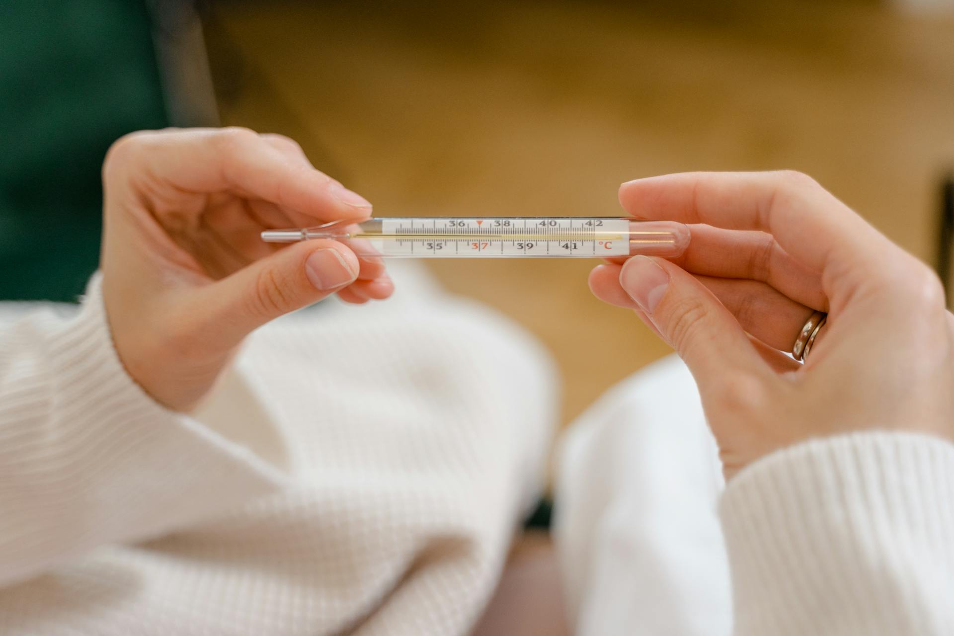 A woman holding a thermometer | Source: Pexels
