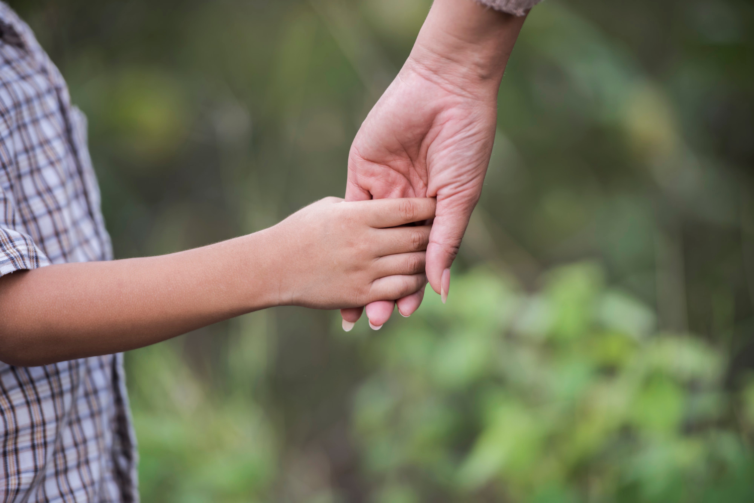 Close-up shot of a mother holding her son's hand | Source: Freepik