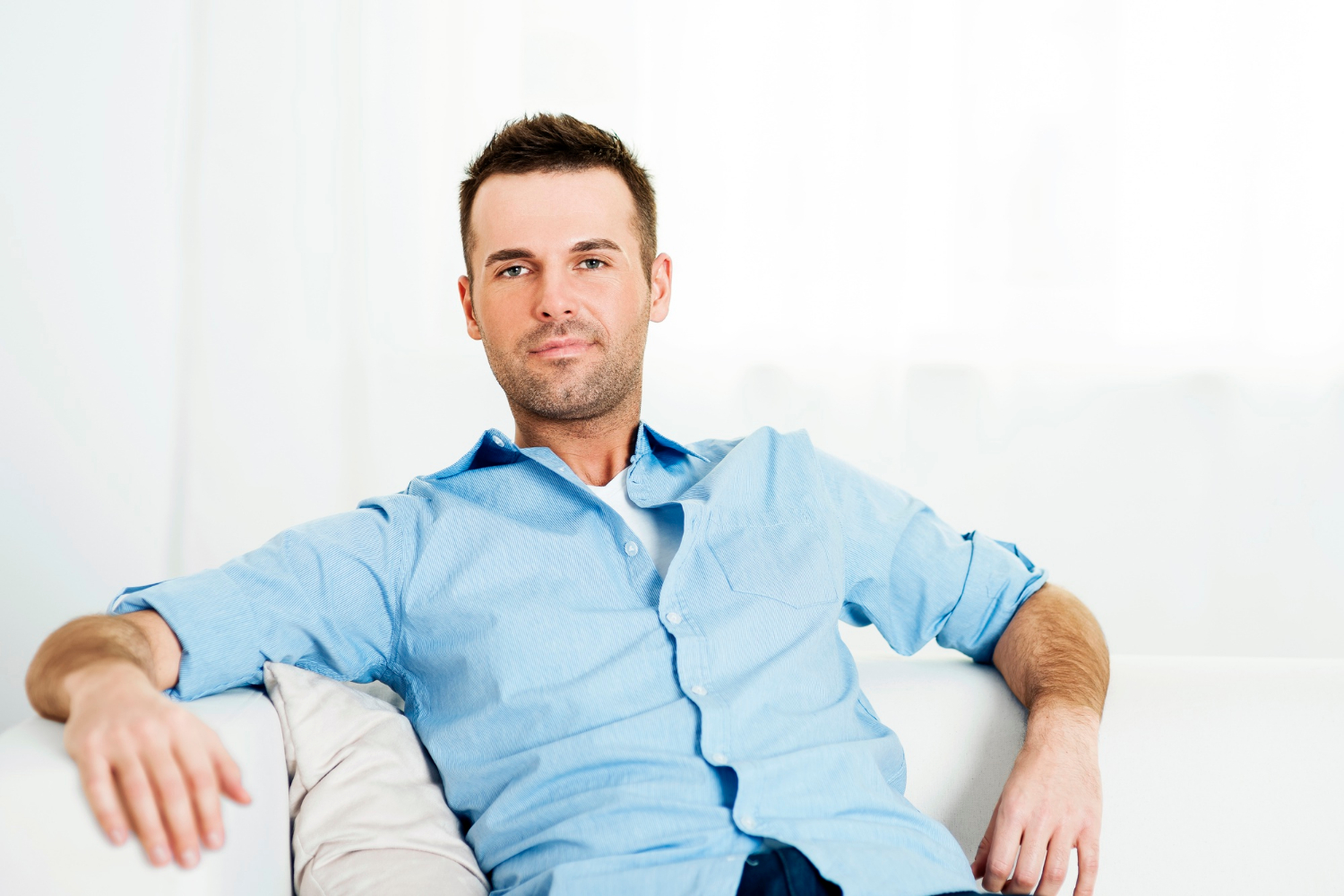 A smiling man sitting on the couch | Source: Freepik