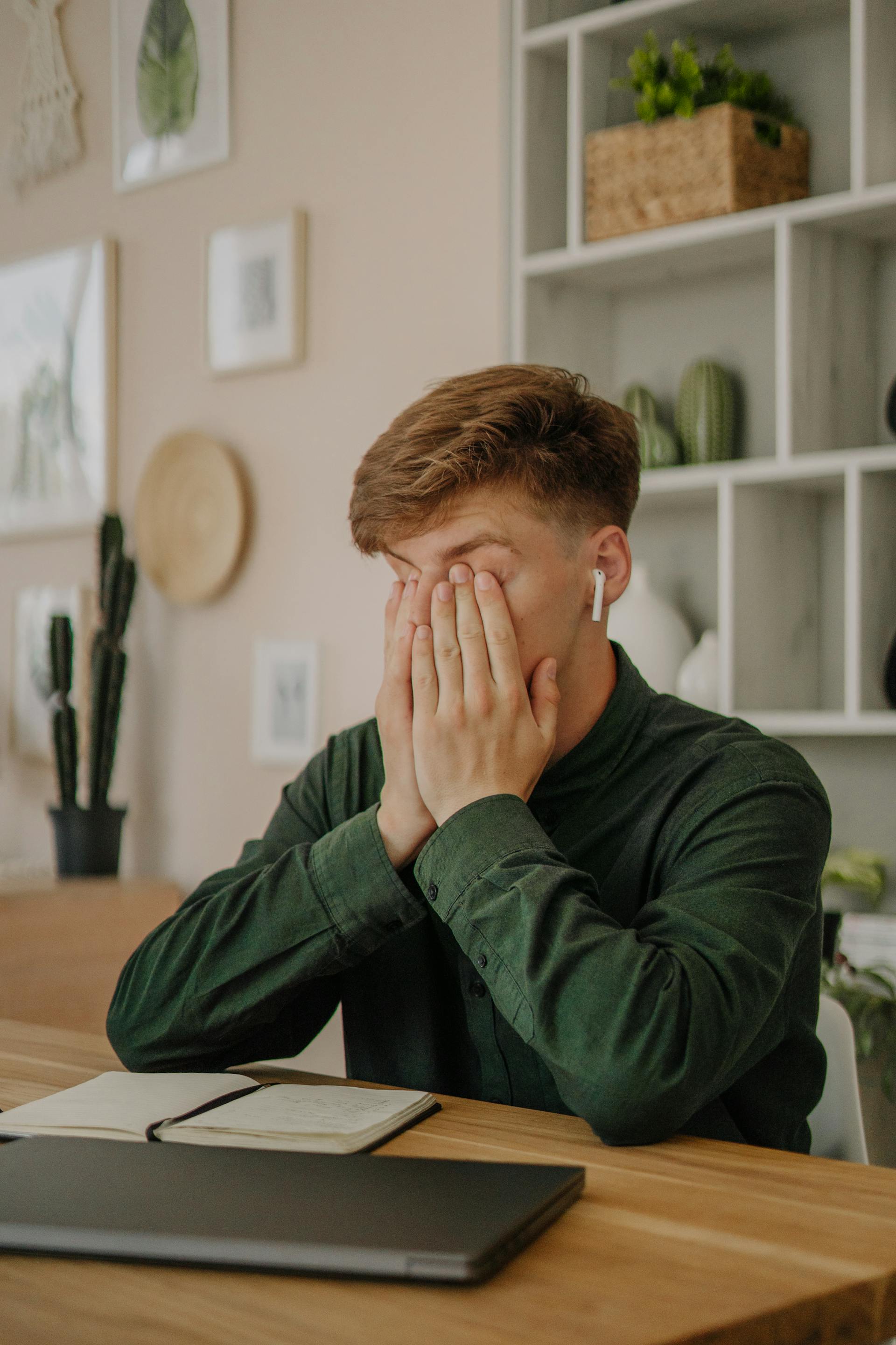 A young man covering his face | Source: Pexels