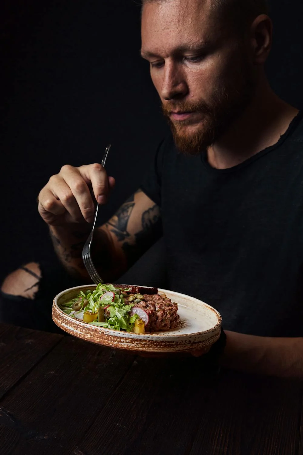 A man eating meat with vegetables | Source: Pexels