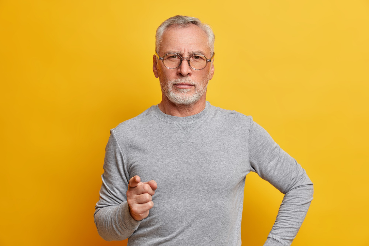 A stern older man pointing his finger as a warning | Source: Freepik