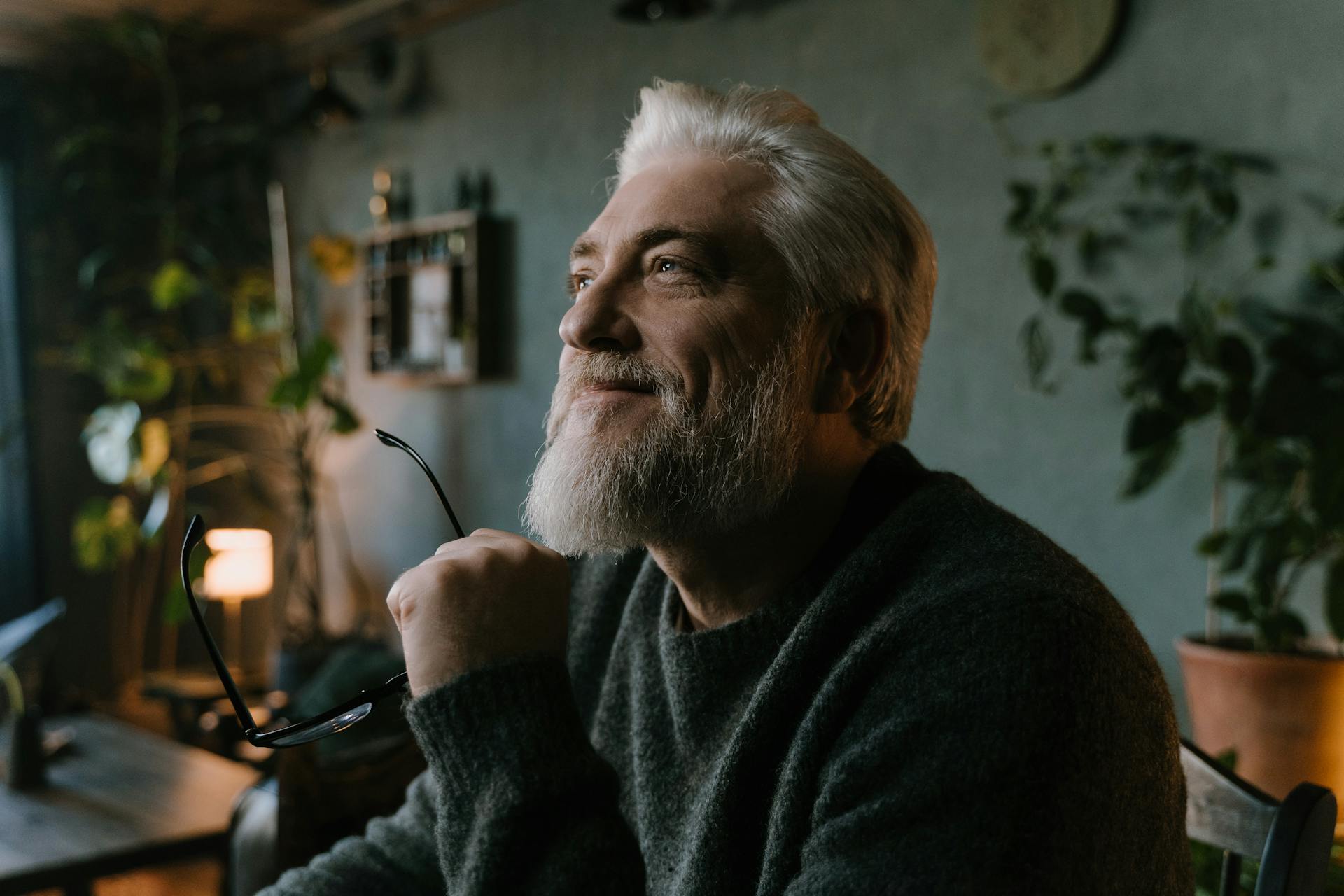 Starszy mężczyzna uśmiecha się, trzymając okulary | Źródło: Pexels