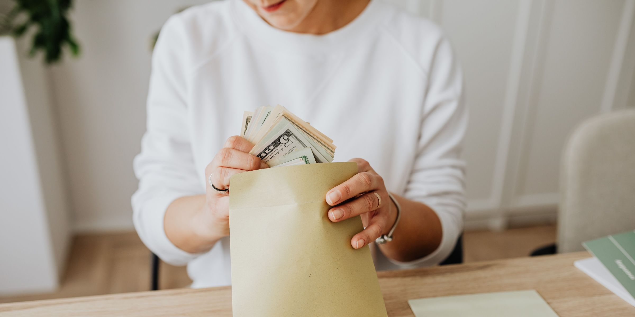 A close-up of a person holding up money from an envelope | Source: Pexels