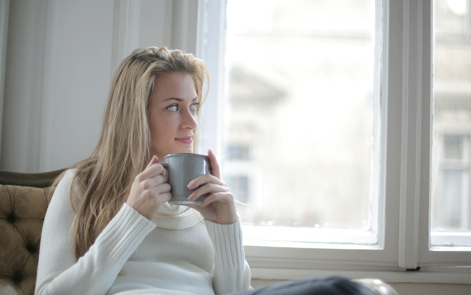 Woman looking sideways while holding a mug of tea | Source: Pexels