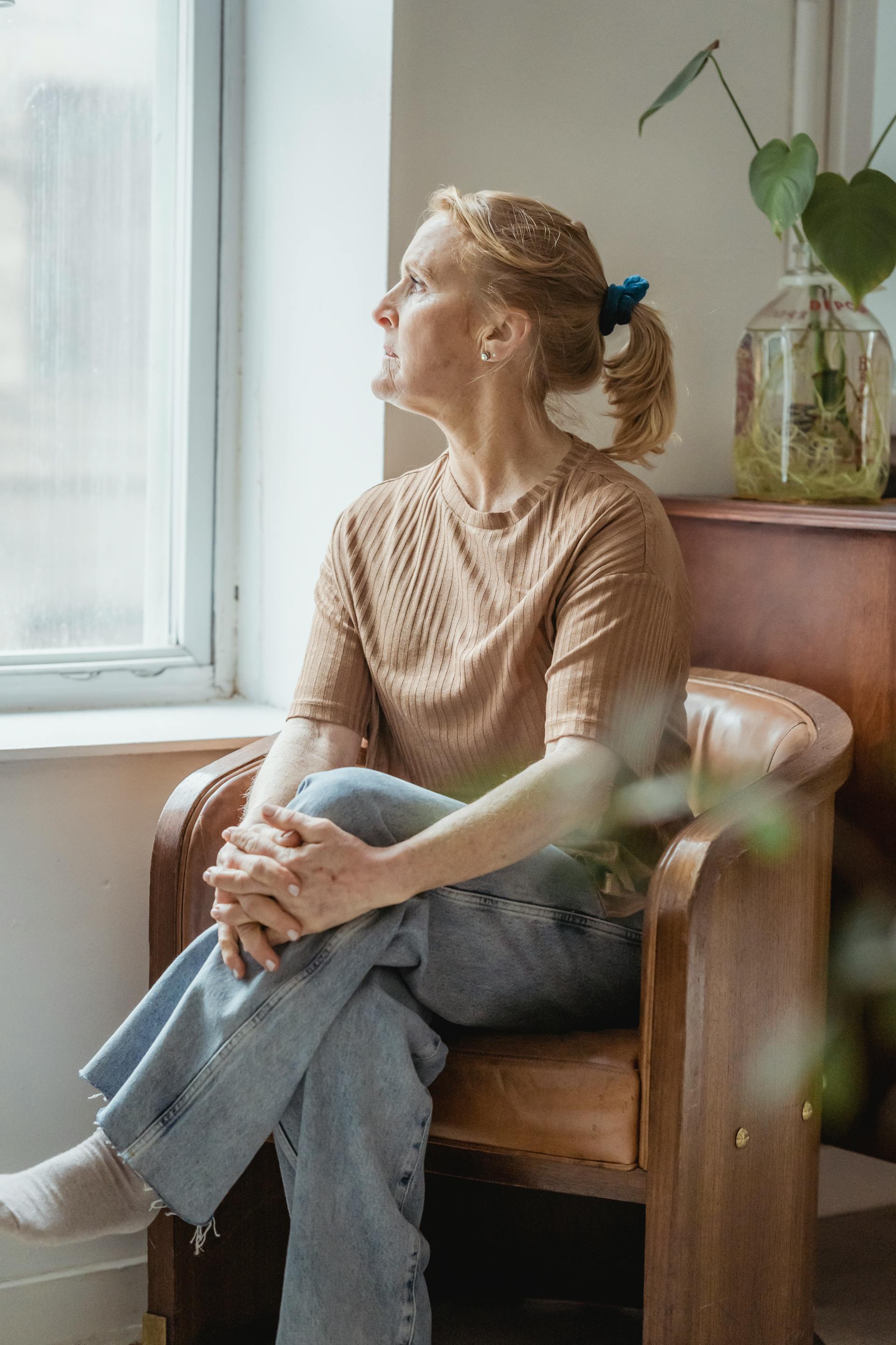 A middle-aged woman sitting in an armchair | Source: Pexels