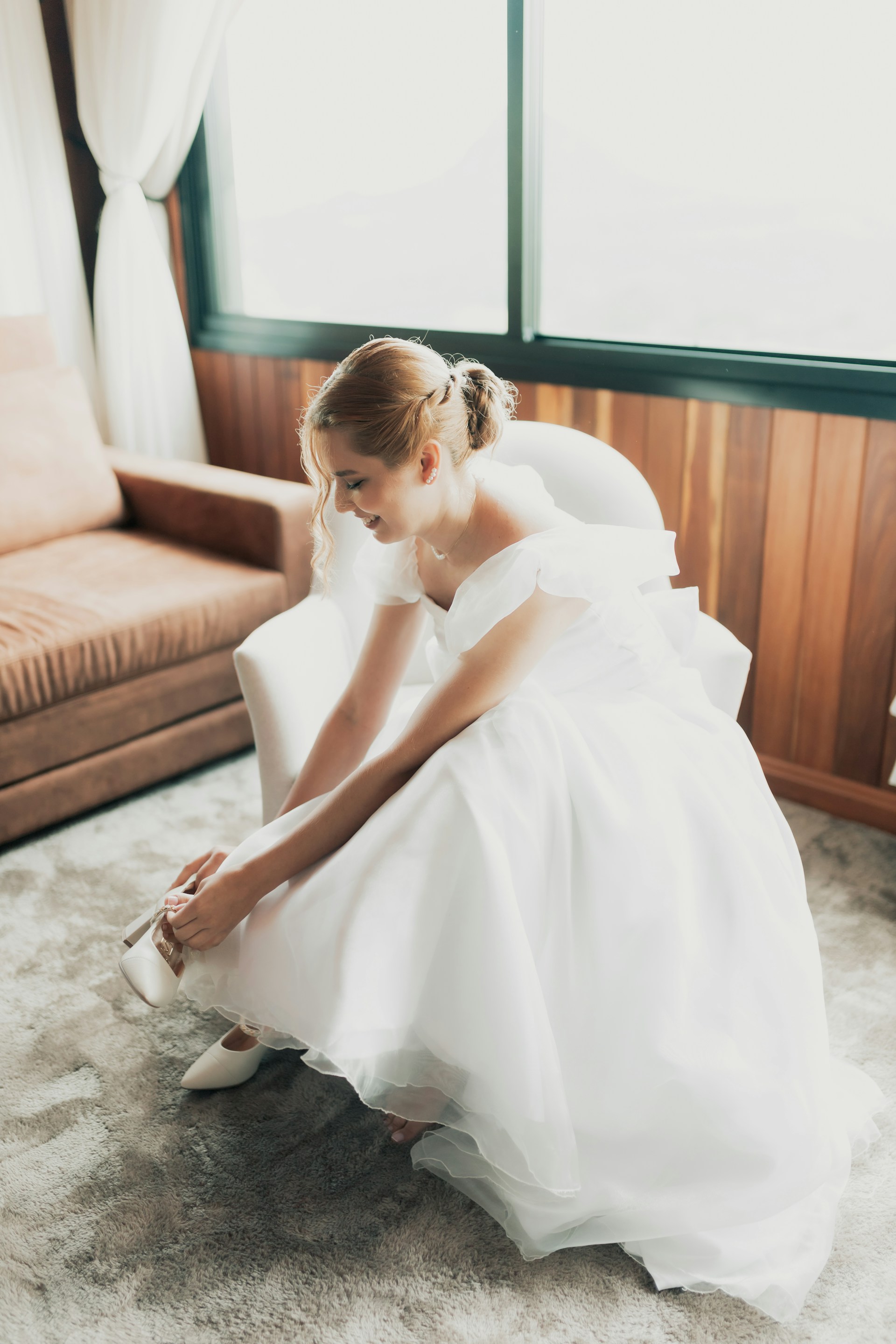 A bride laughing while fixing her shoe | Source: Unsplash