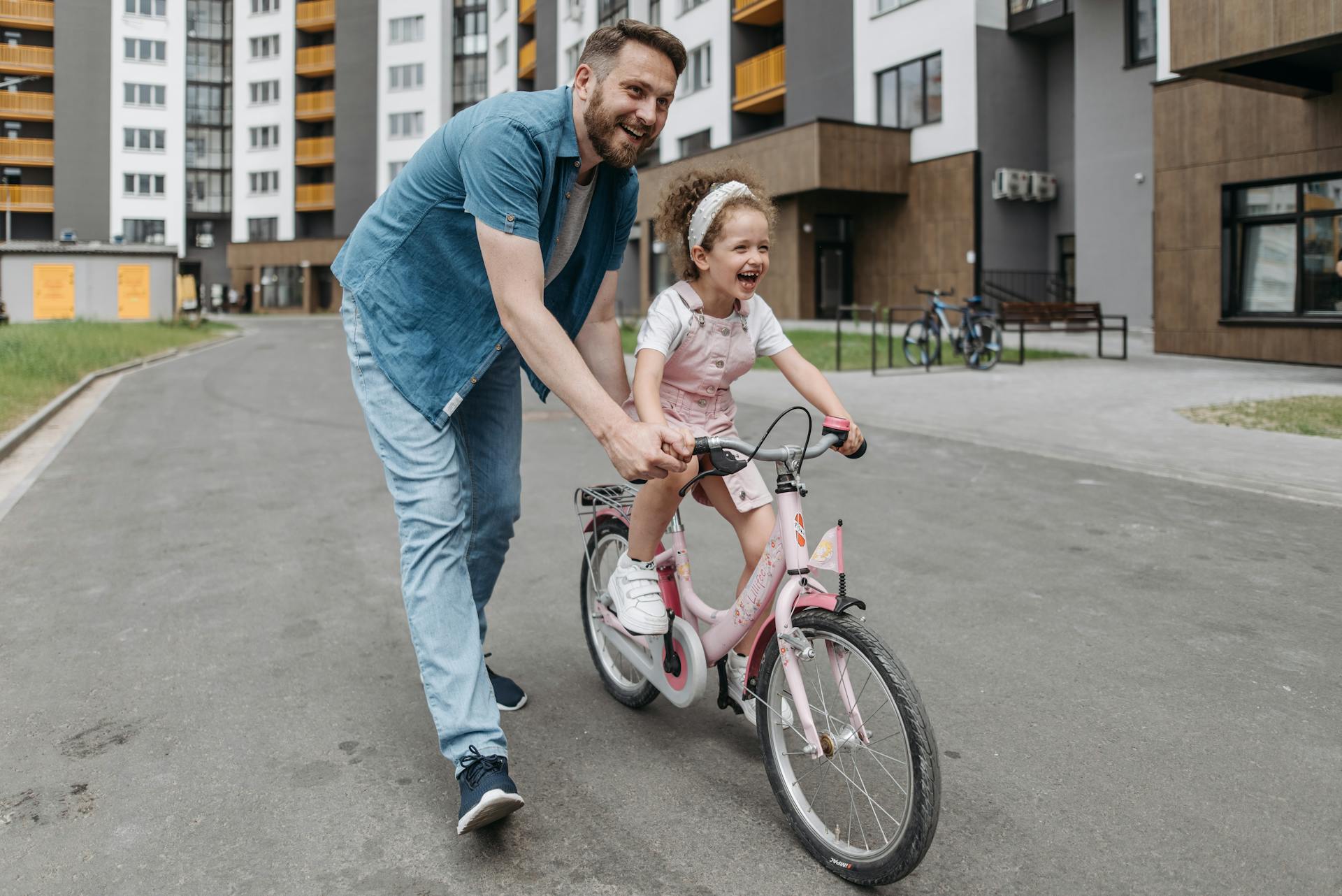 A man helping his daughter ride a bike | Source: Pexels