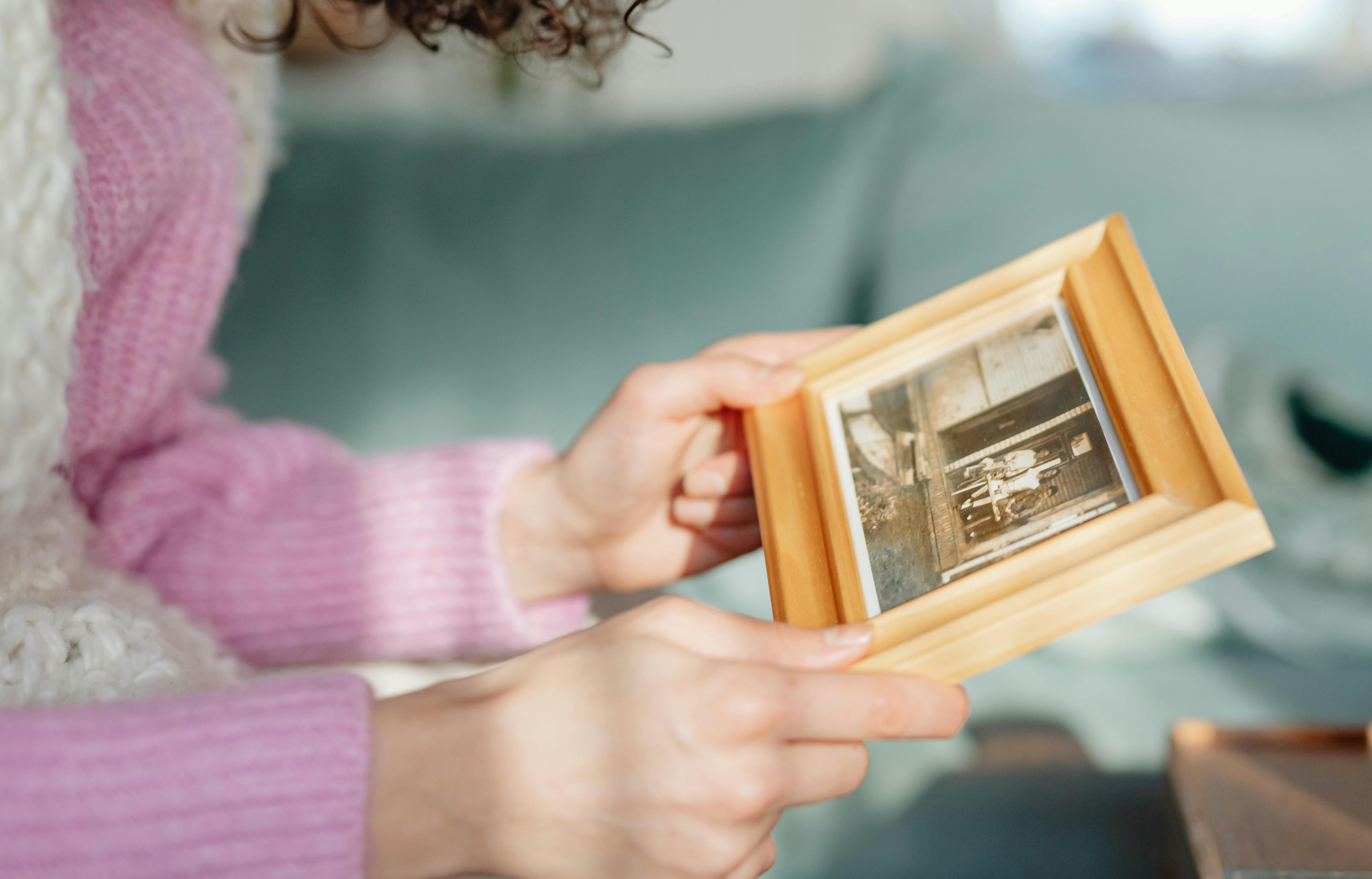 A woman holding a photo frame | Source: Pexels