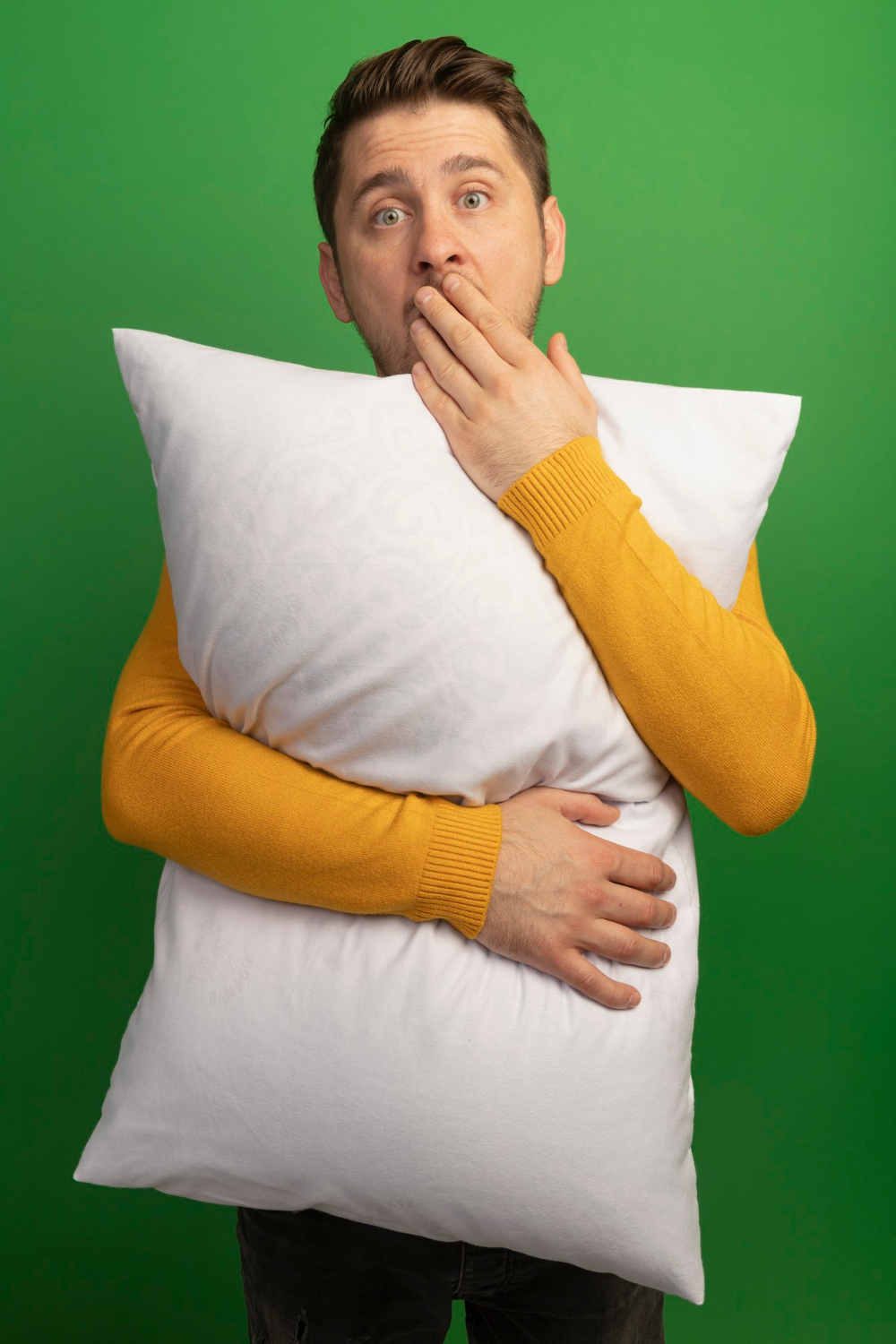 A stunned man holding a pillow | Source: Freepik