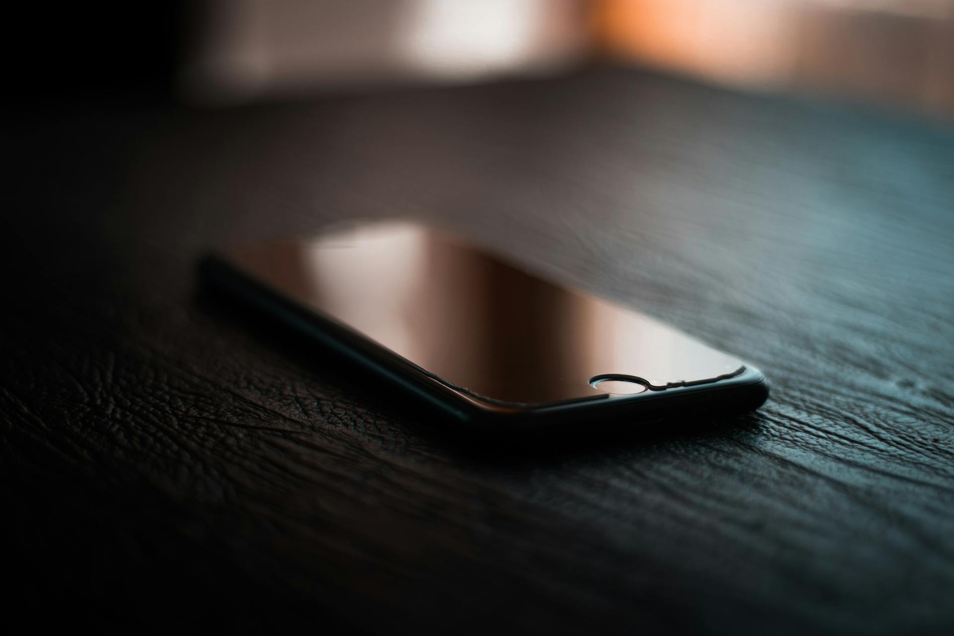 A phone on a wooden table | Source: Pexels