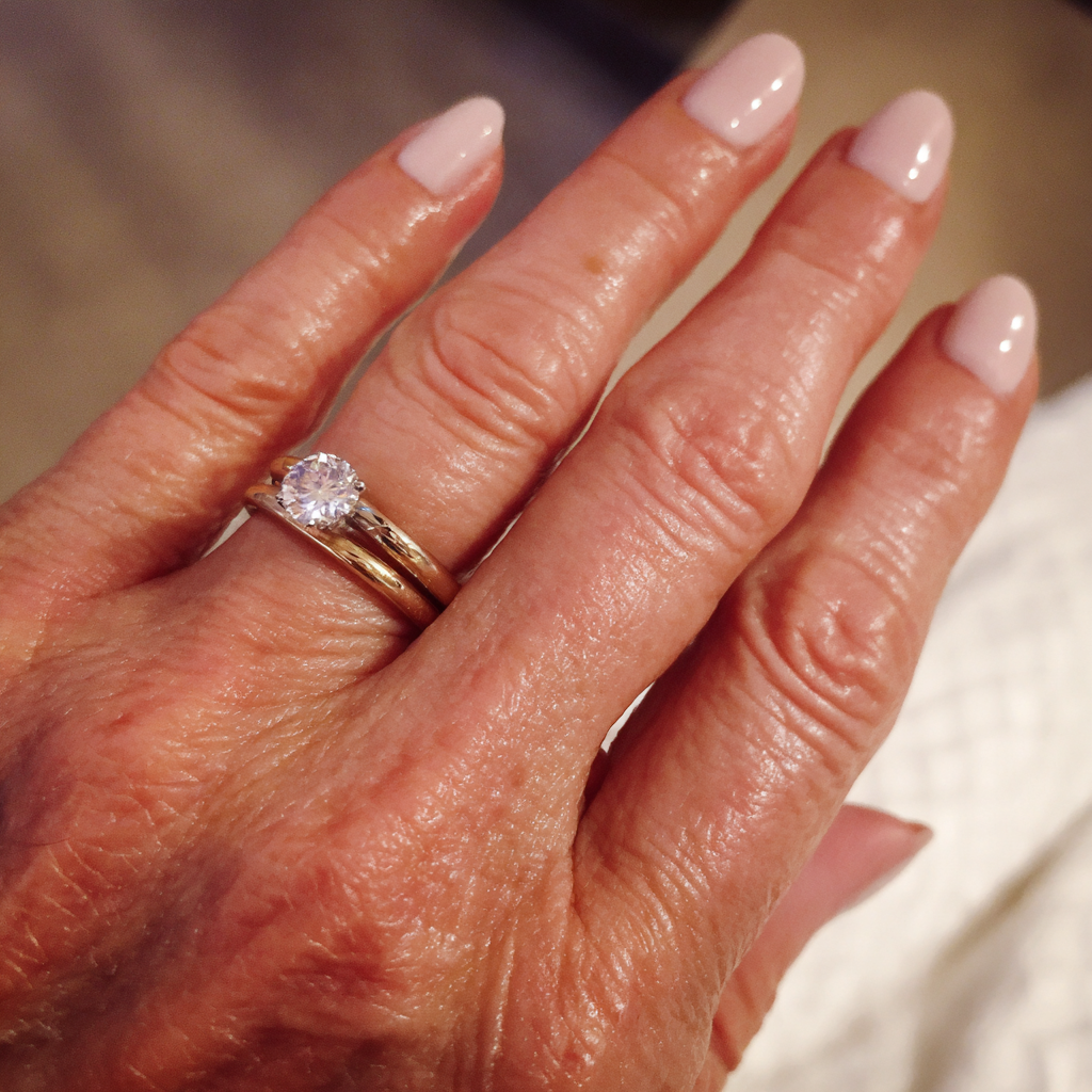 A close-up of a woman's hand and wedding rings | Source: Midjourney