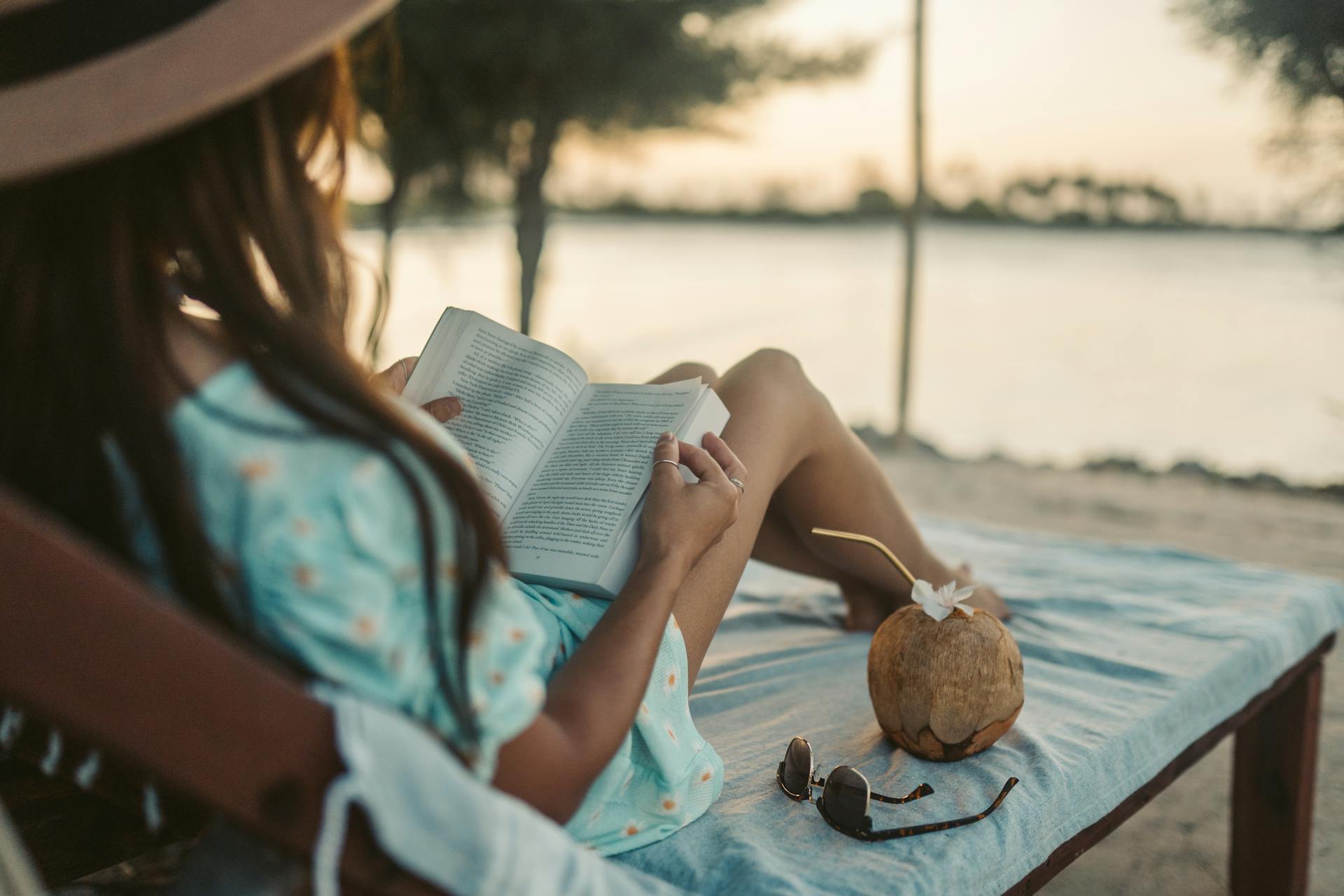 A woman lying on a lounger and reading a book | Source: Pexels
