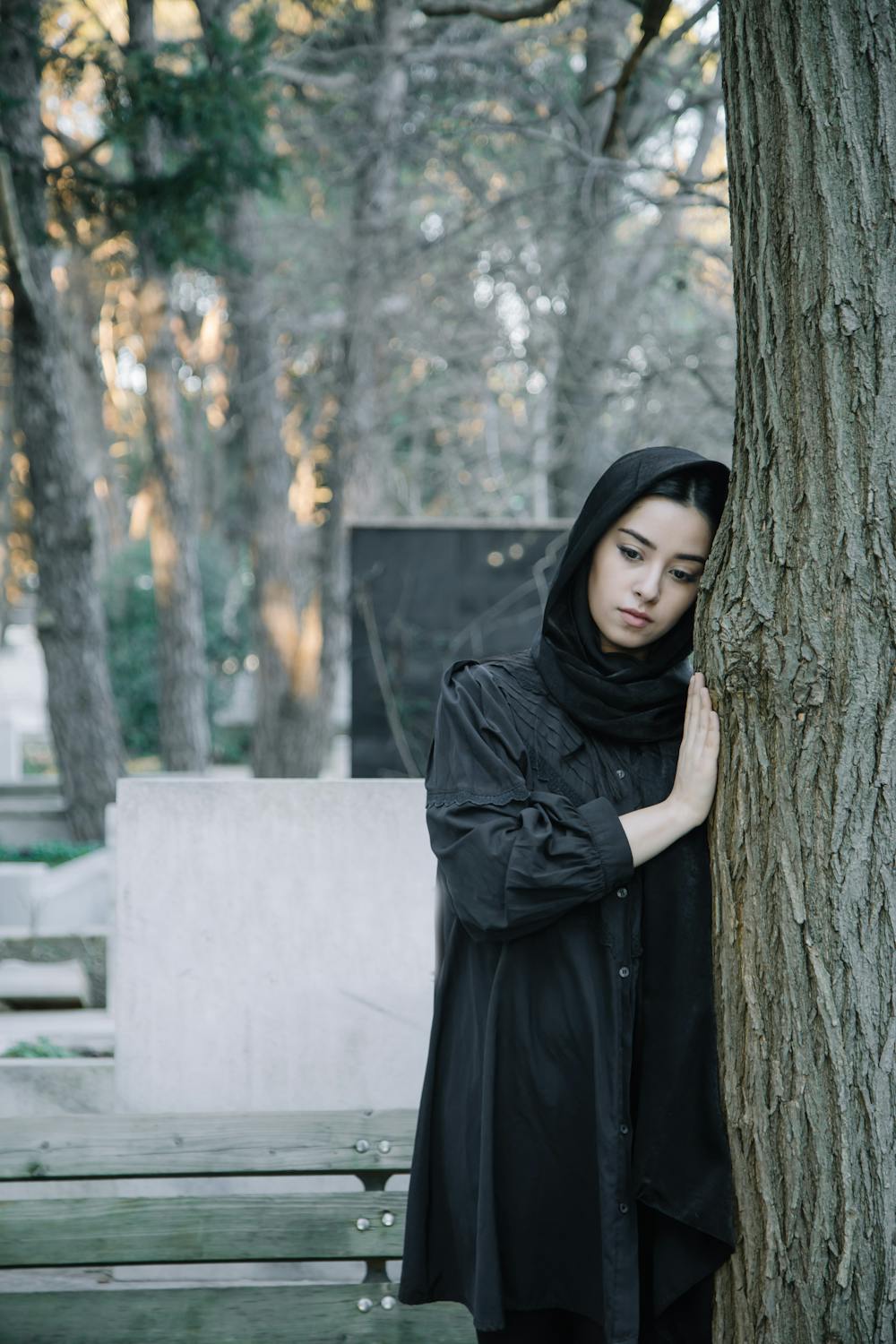 A shy woman at a cemetery ⏐ Source: Pexels