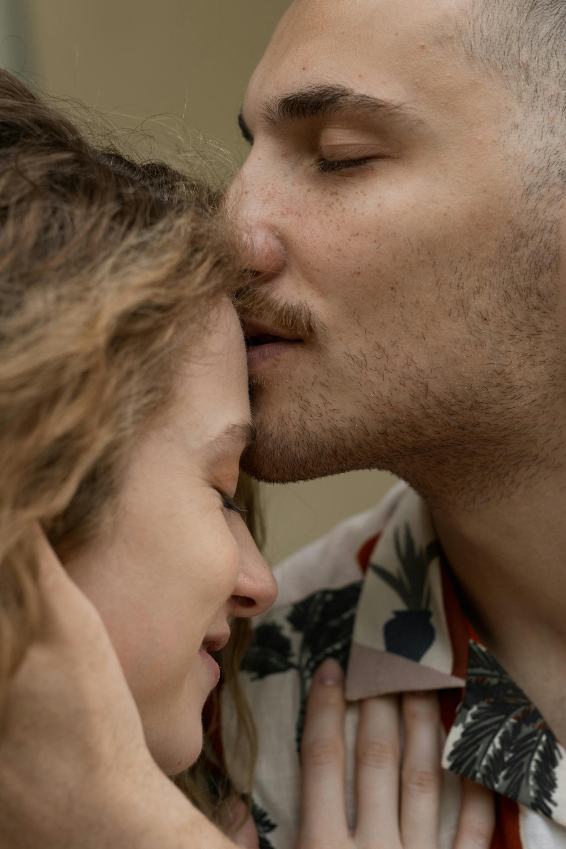 A man kissing a woman on the forehead | Source: Pexels