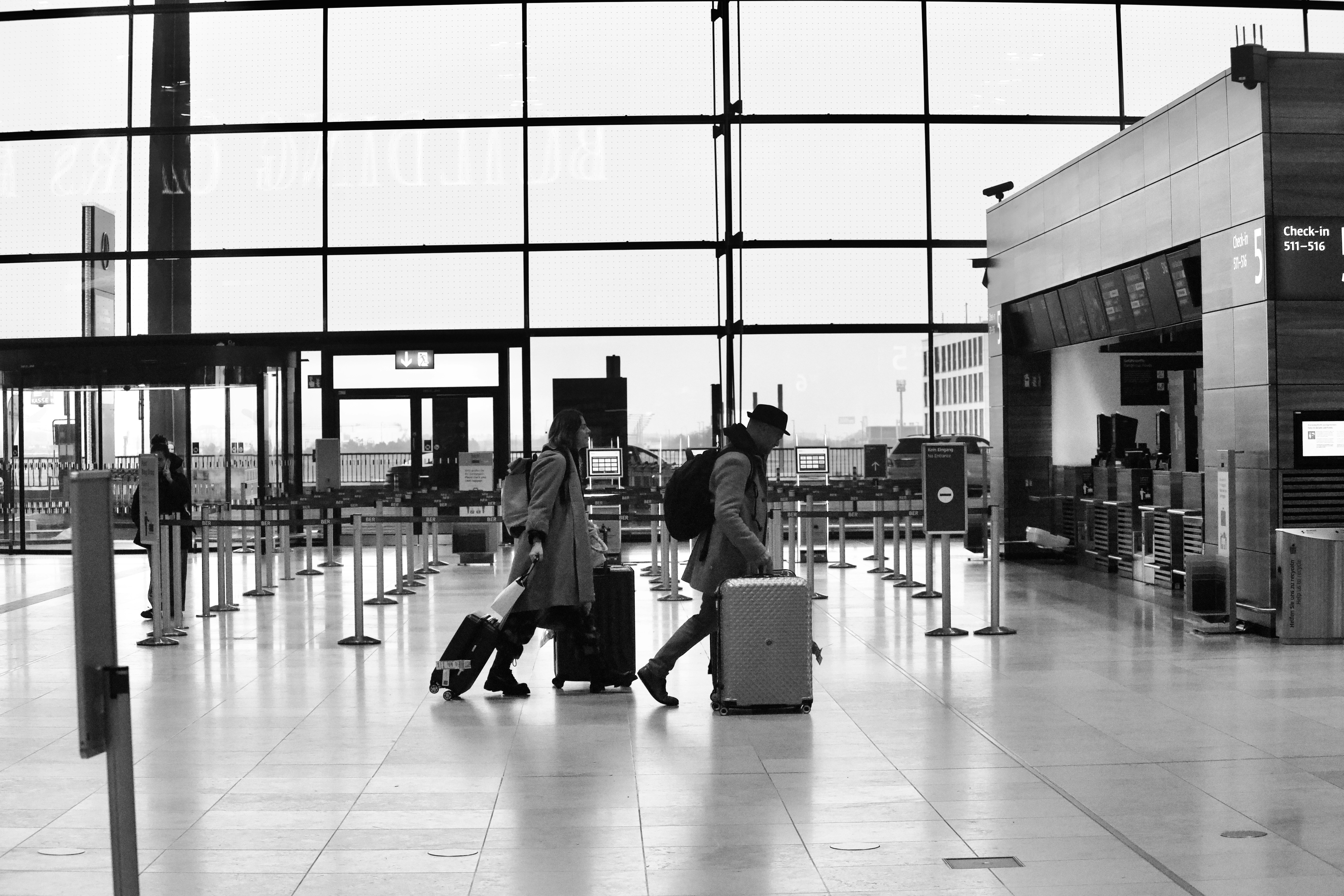 Couple walking through an airport terminal with luggage | Source: Unsplash