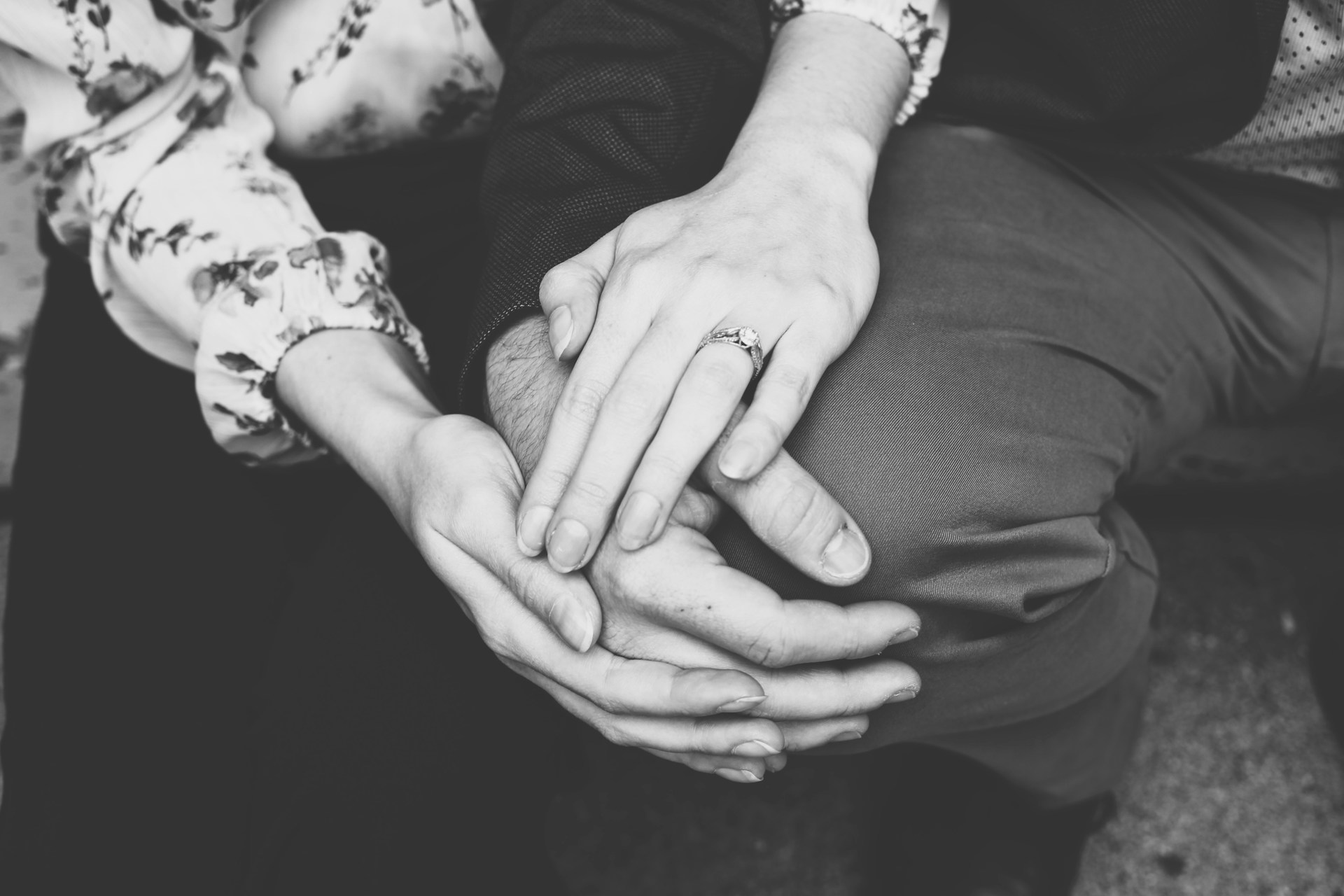 Grayscale shot of a couple holding hands | Source: Unsplash