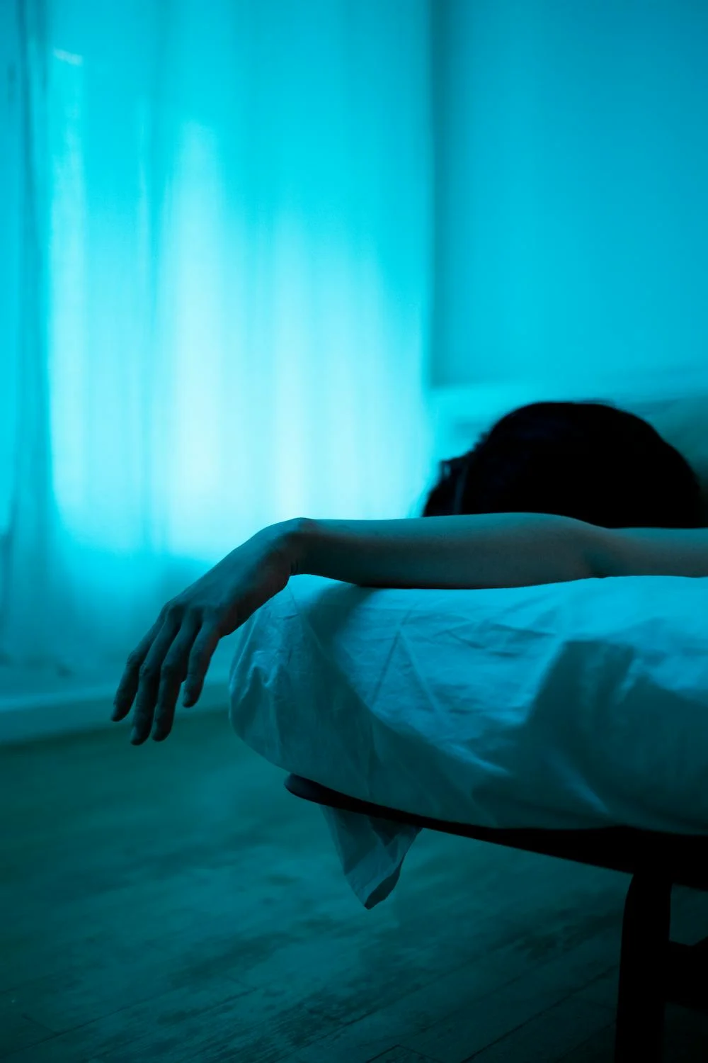 A sick woman lying in her bed with dim lights | Source: Pexels