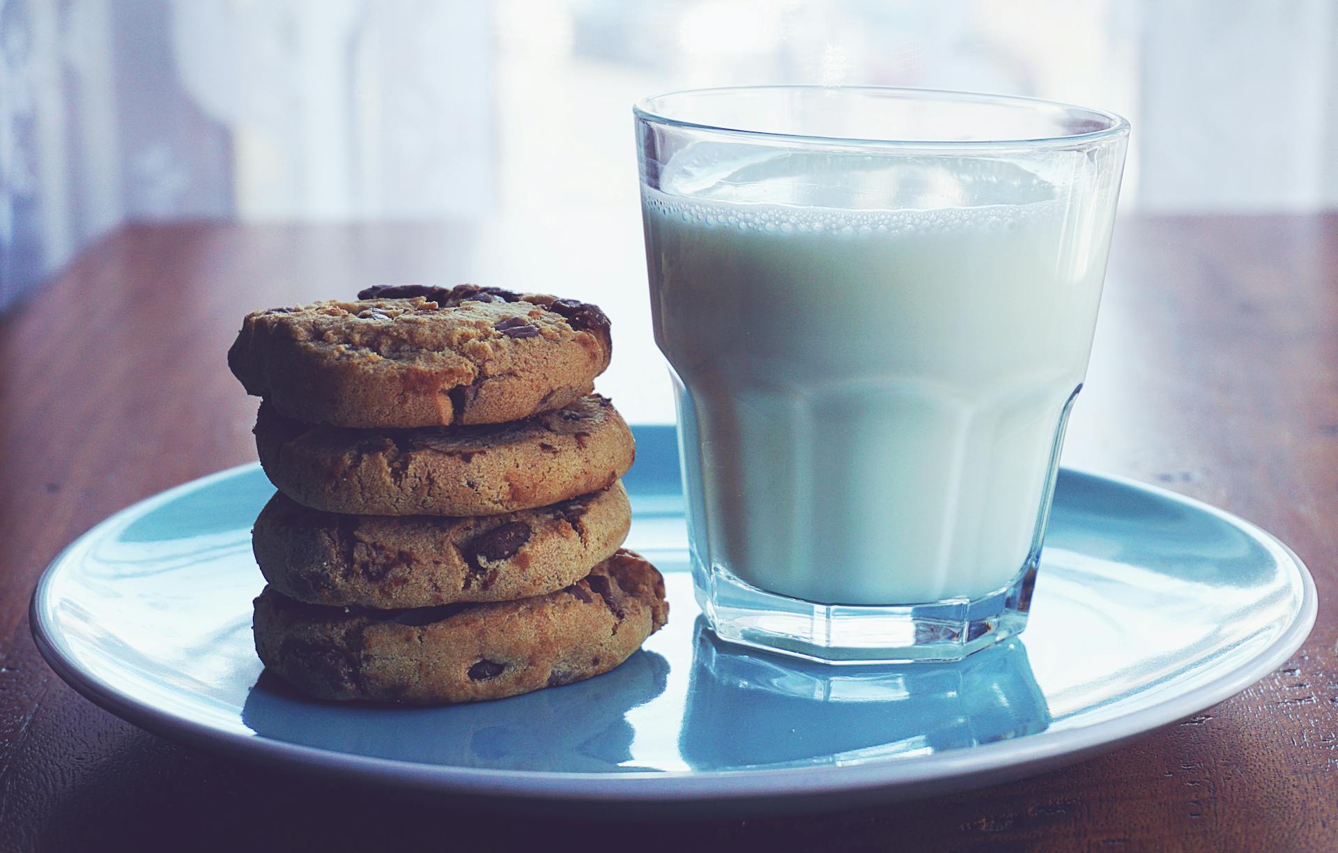 Chocolate chip cookies and a glass of milk | Source: Midjourney