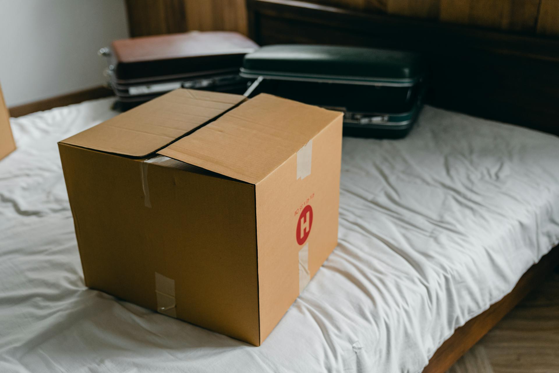 Boxes and suitcases on a bed | Source: Pexels