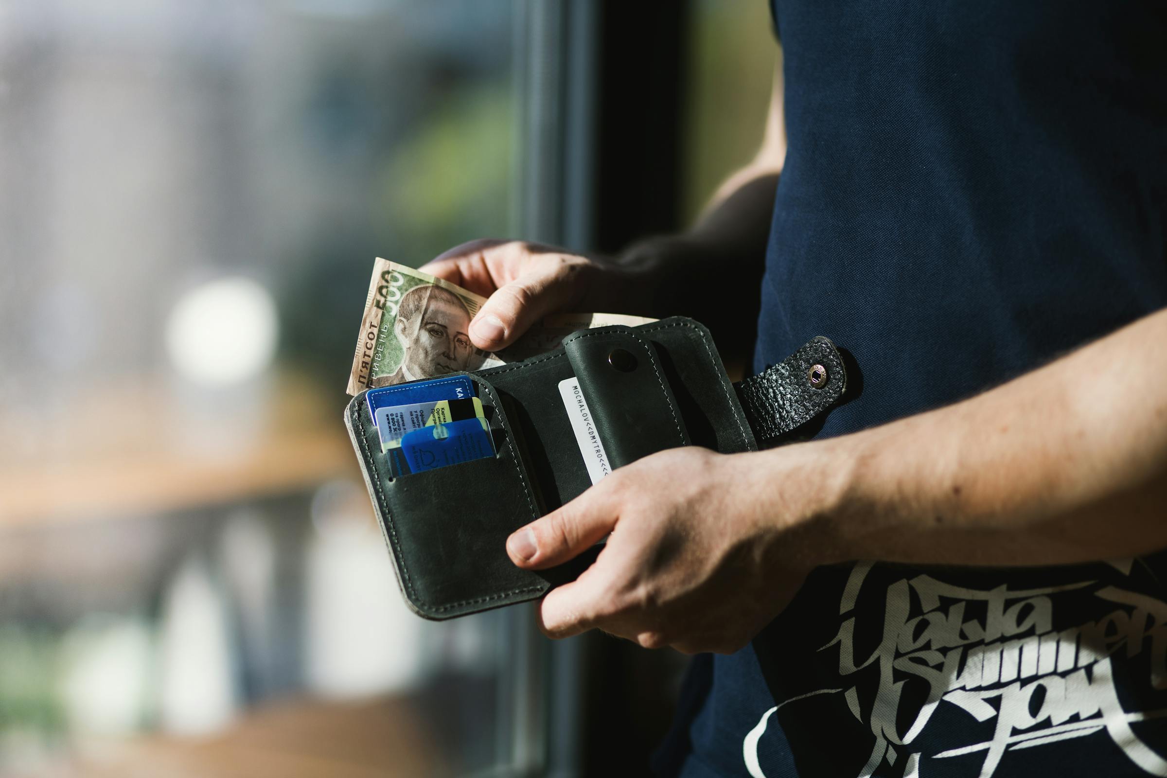 A man getting cash out of his wallet | Source: Pexels