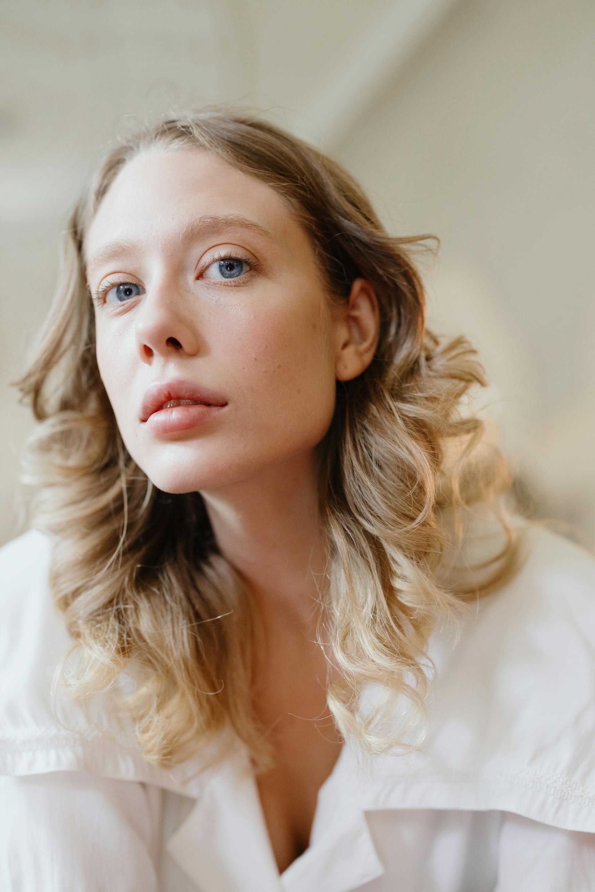 A young blonde woman with blue eyes and wavy hair | Source: Pexels