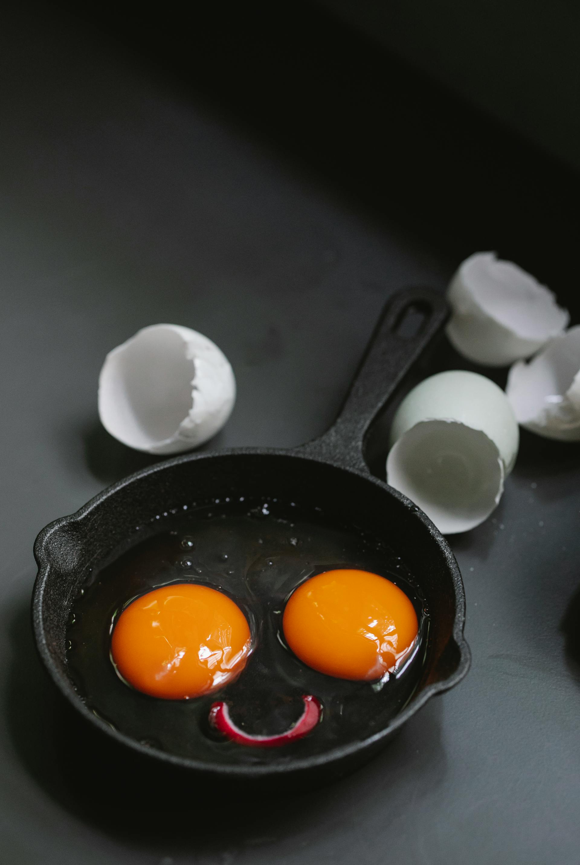 A frying pan with egg yolks forming a funny face | Source: Pexels