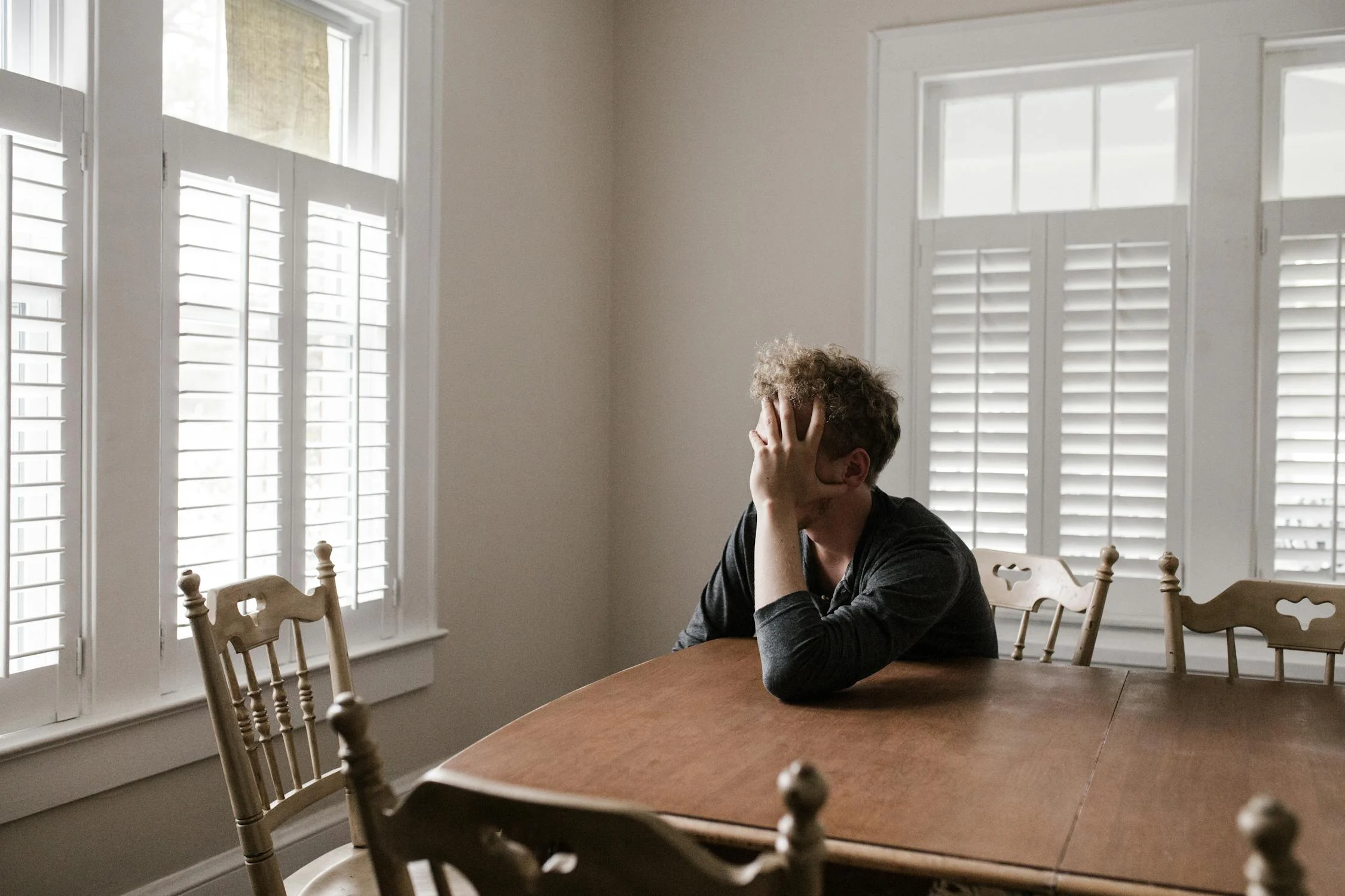 Un hombre triste en su mesa ⏐ Fuente: Pexels