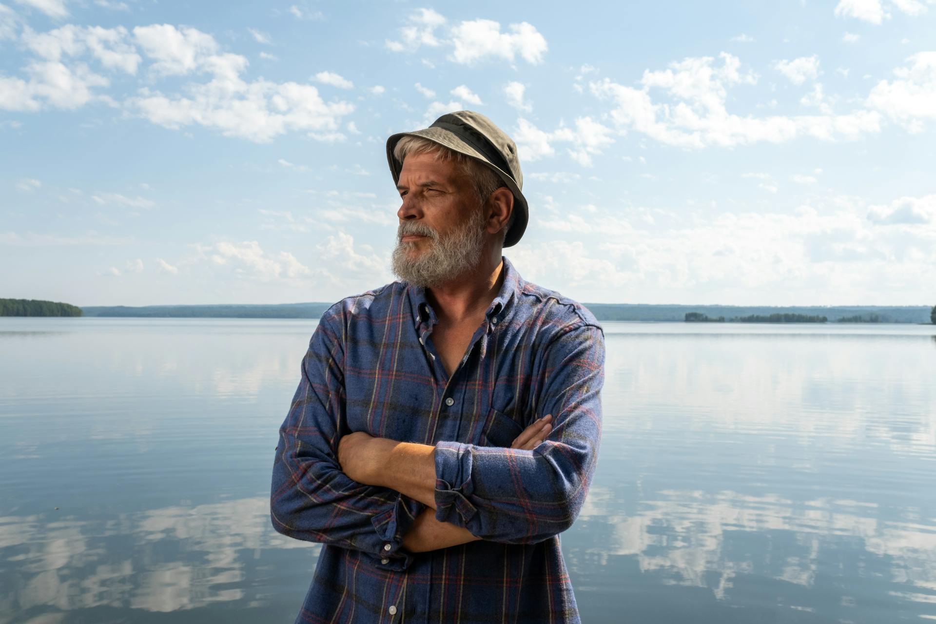 An elderly man standing on a pier | Source: Pexels