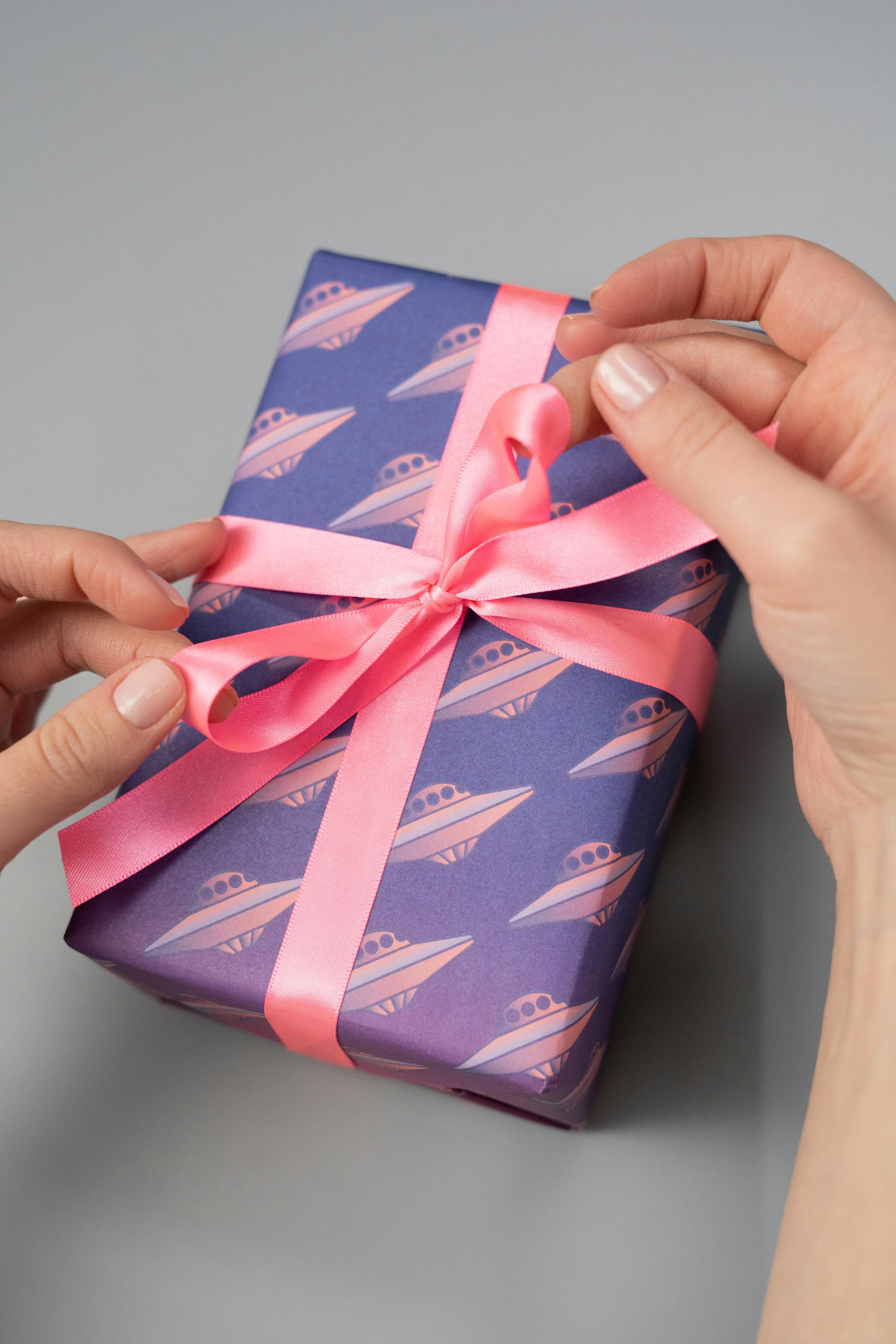 A close-up shot of a person holding a gift box with a pink ribbon | Source: Pexels