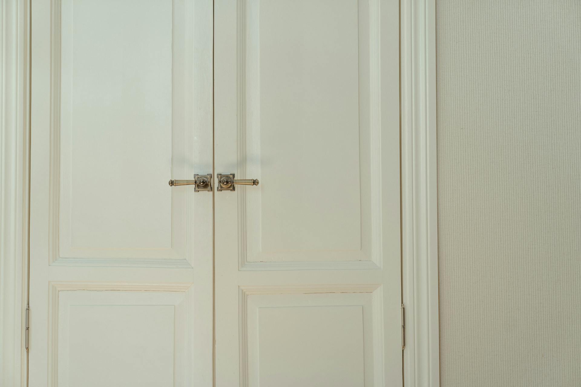 A white wooden door with silver handles | Source: Pexels