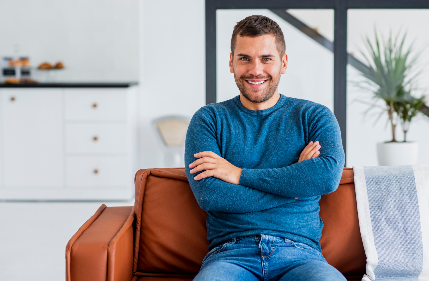 A smiling man sitting on the couch | Source: Freepik