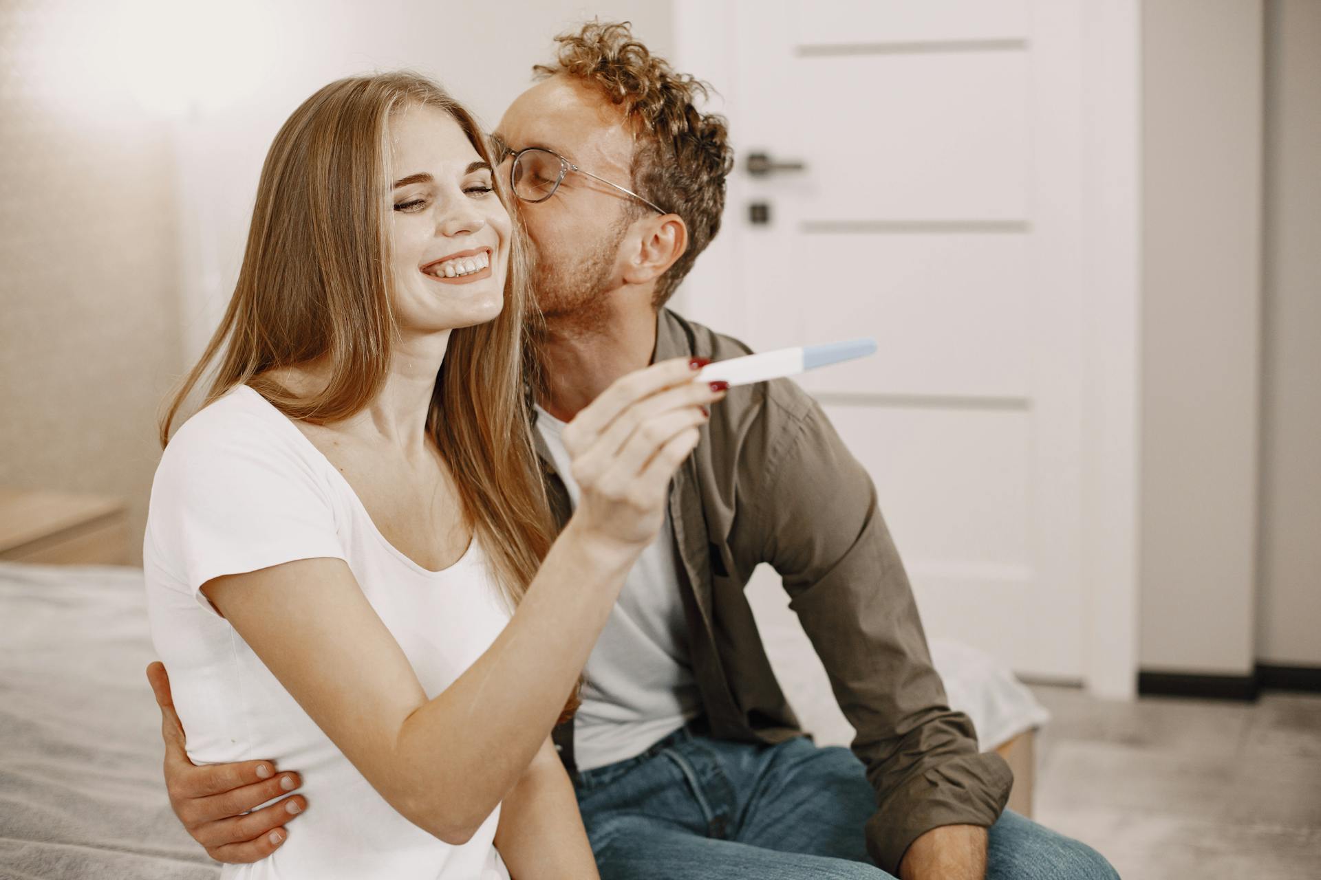 A man kissing a woman on the cheek as she reveals her pregnancy | Source: Pexels