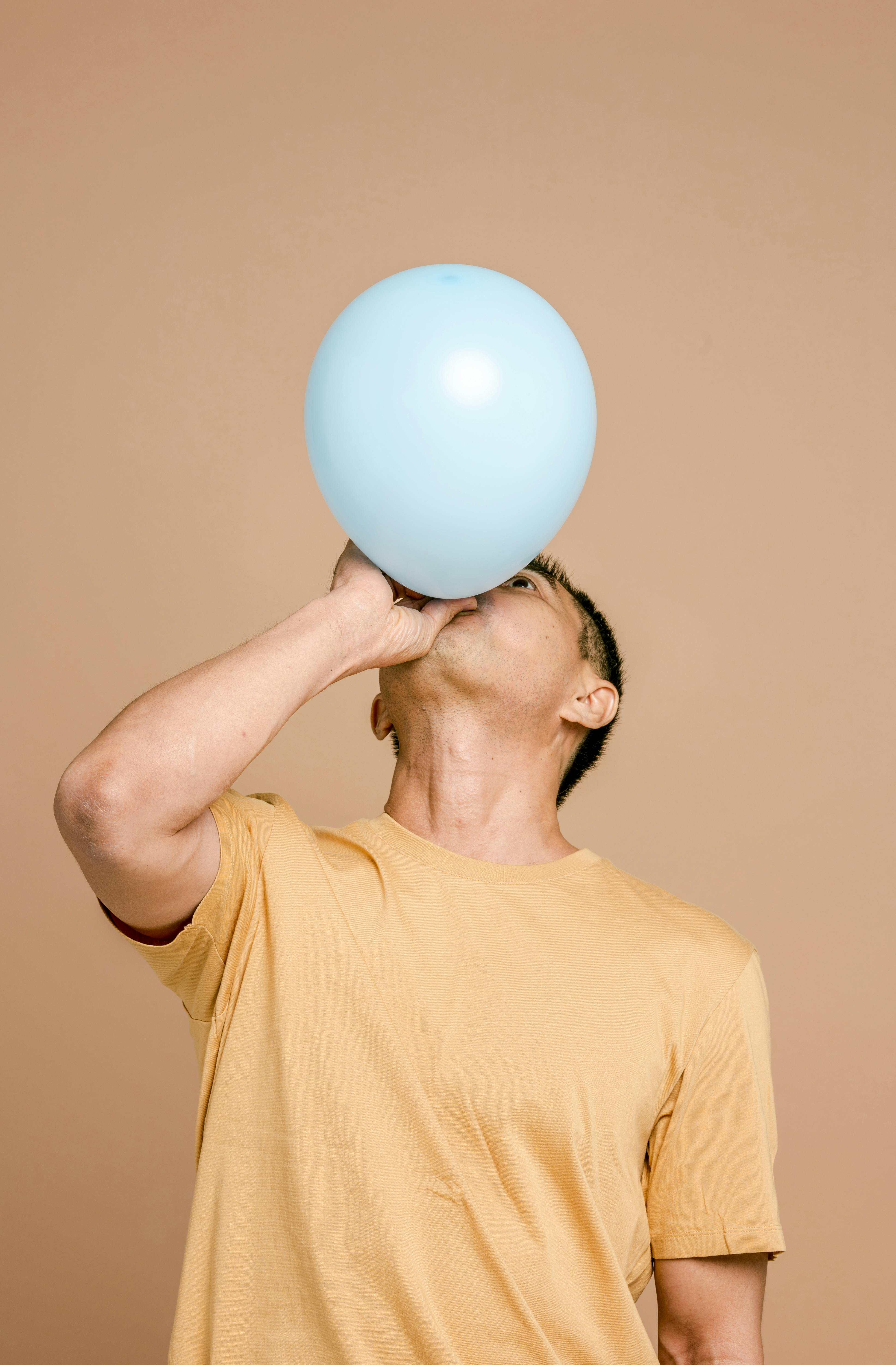 A man blowing up a balloon | Source: Pexels