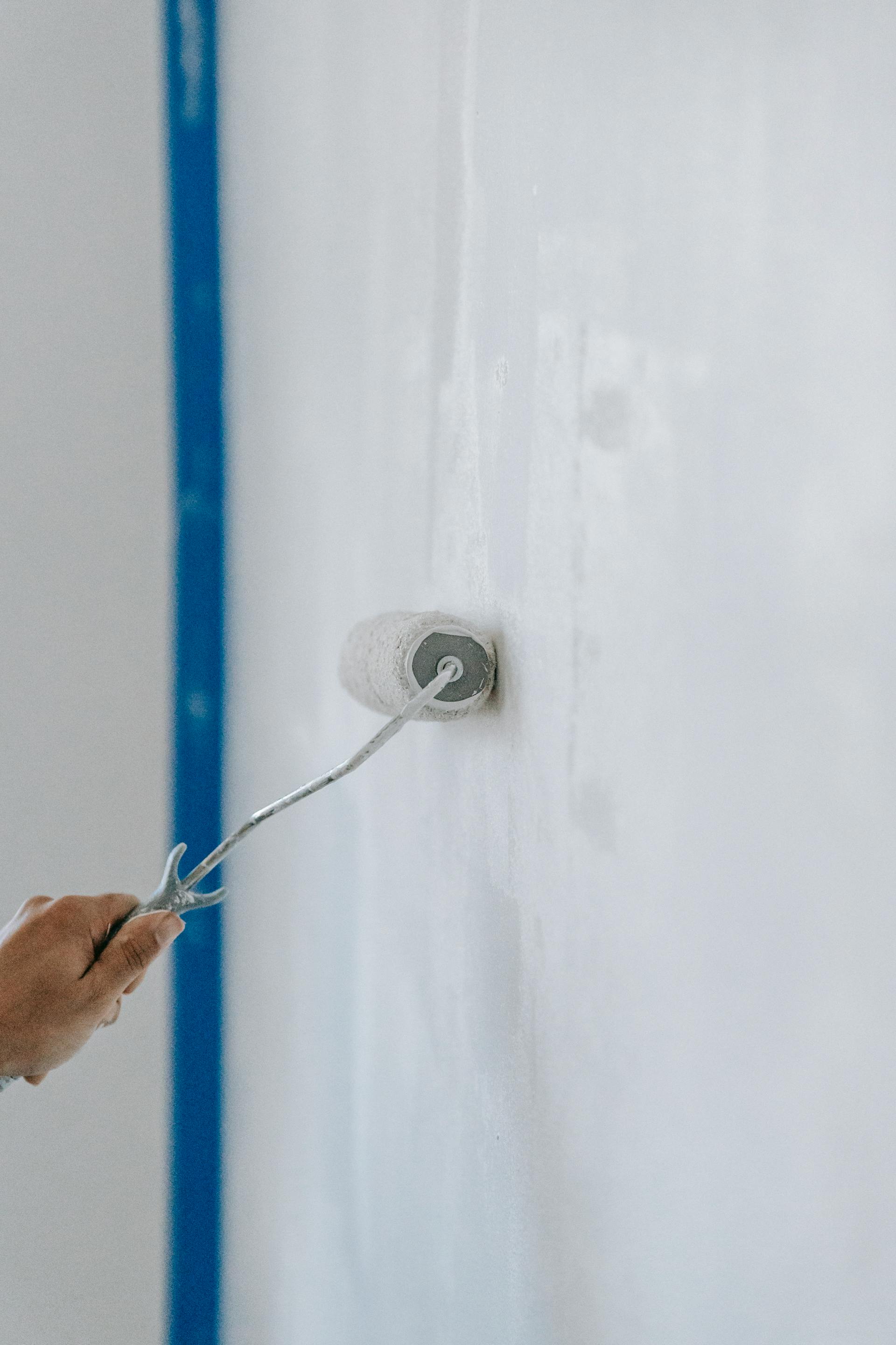 A person painting the wall with a roller | Source: Pexels