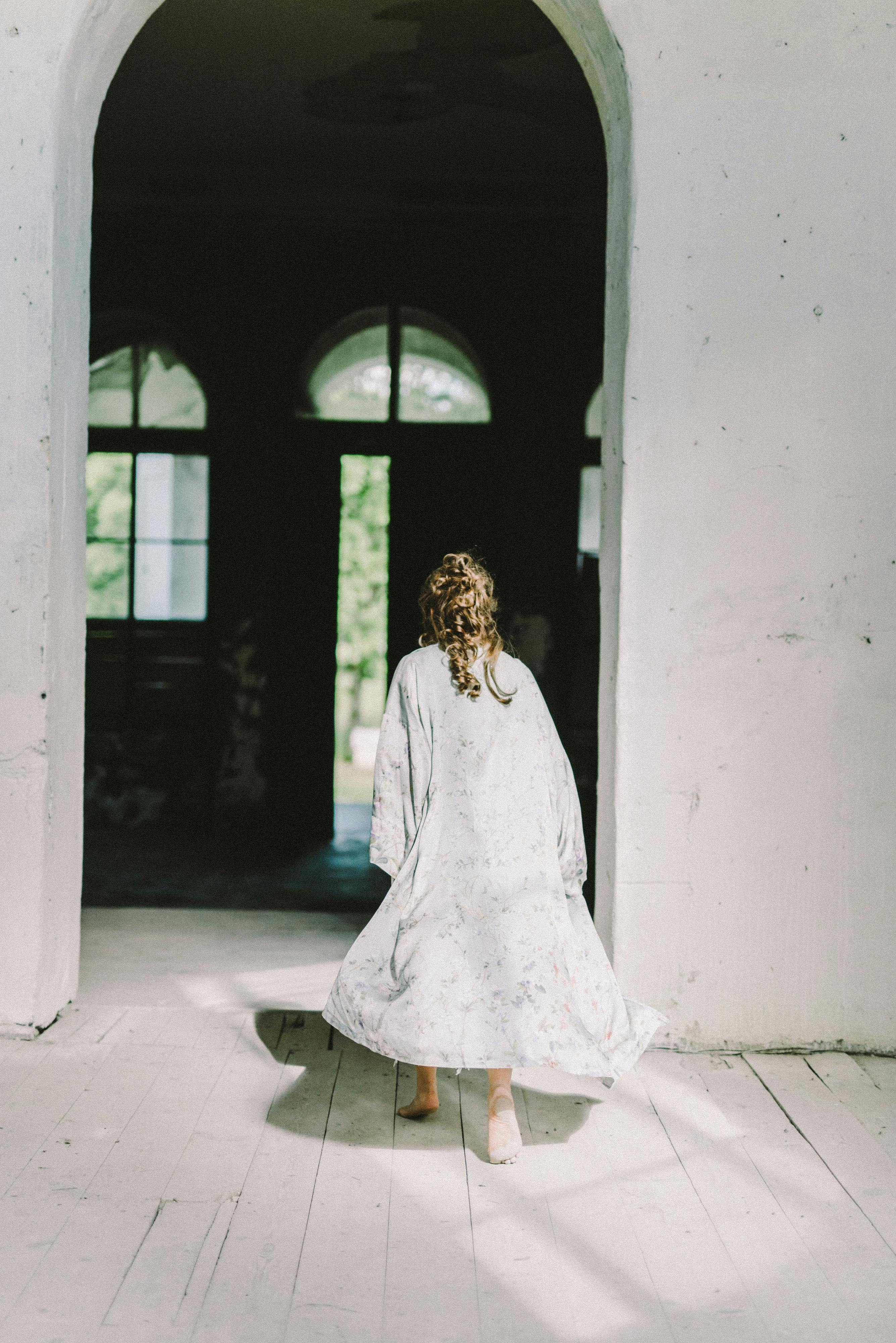 Back view of a woman walking in an arch doorway | Source: Pexels