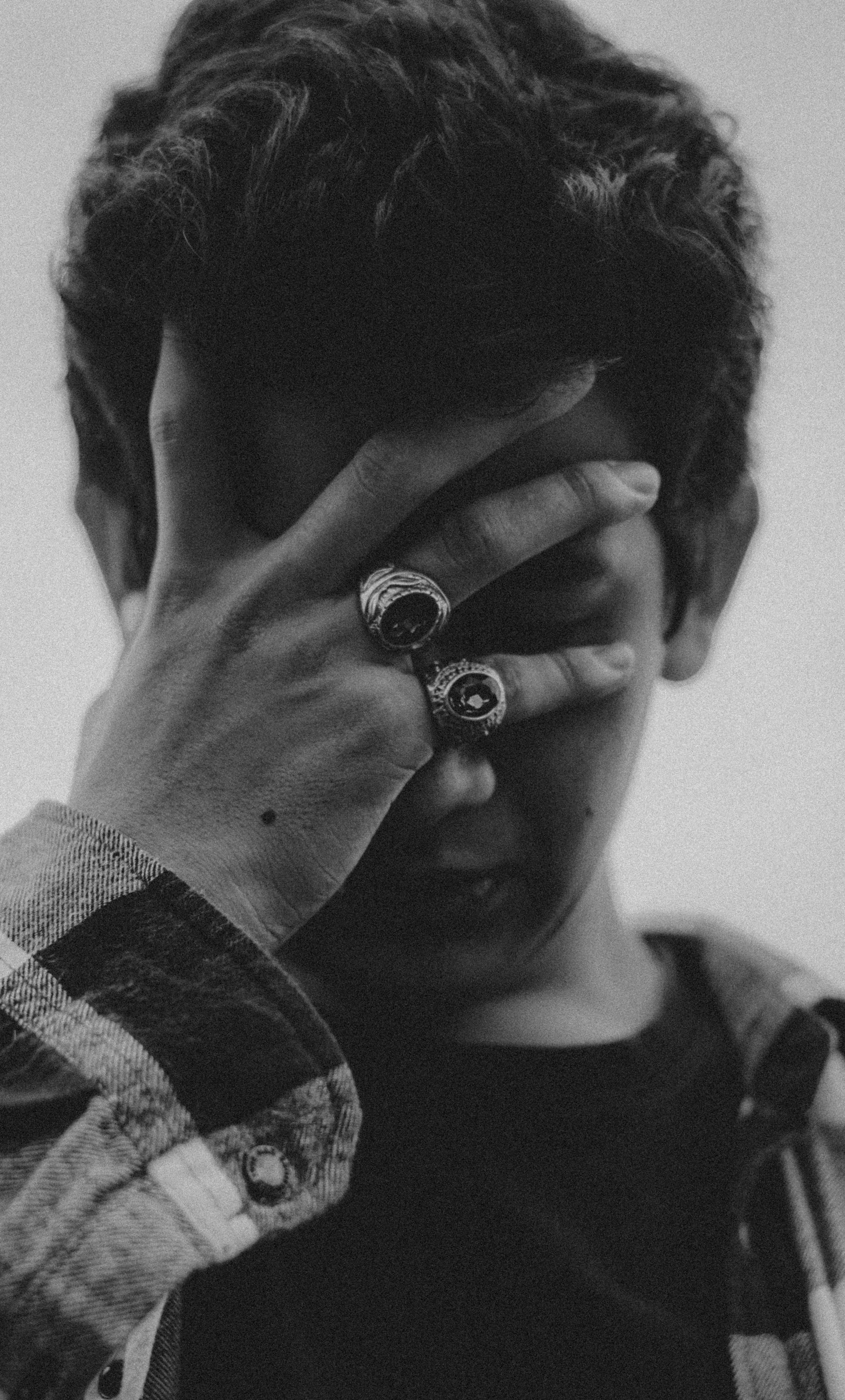 A grayscale photo of a youngster covering his face | Source: Pexels