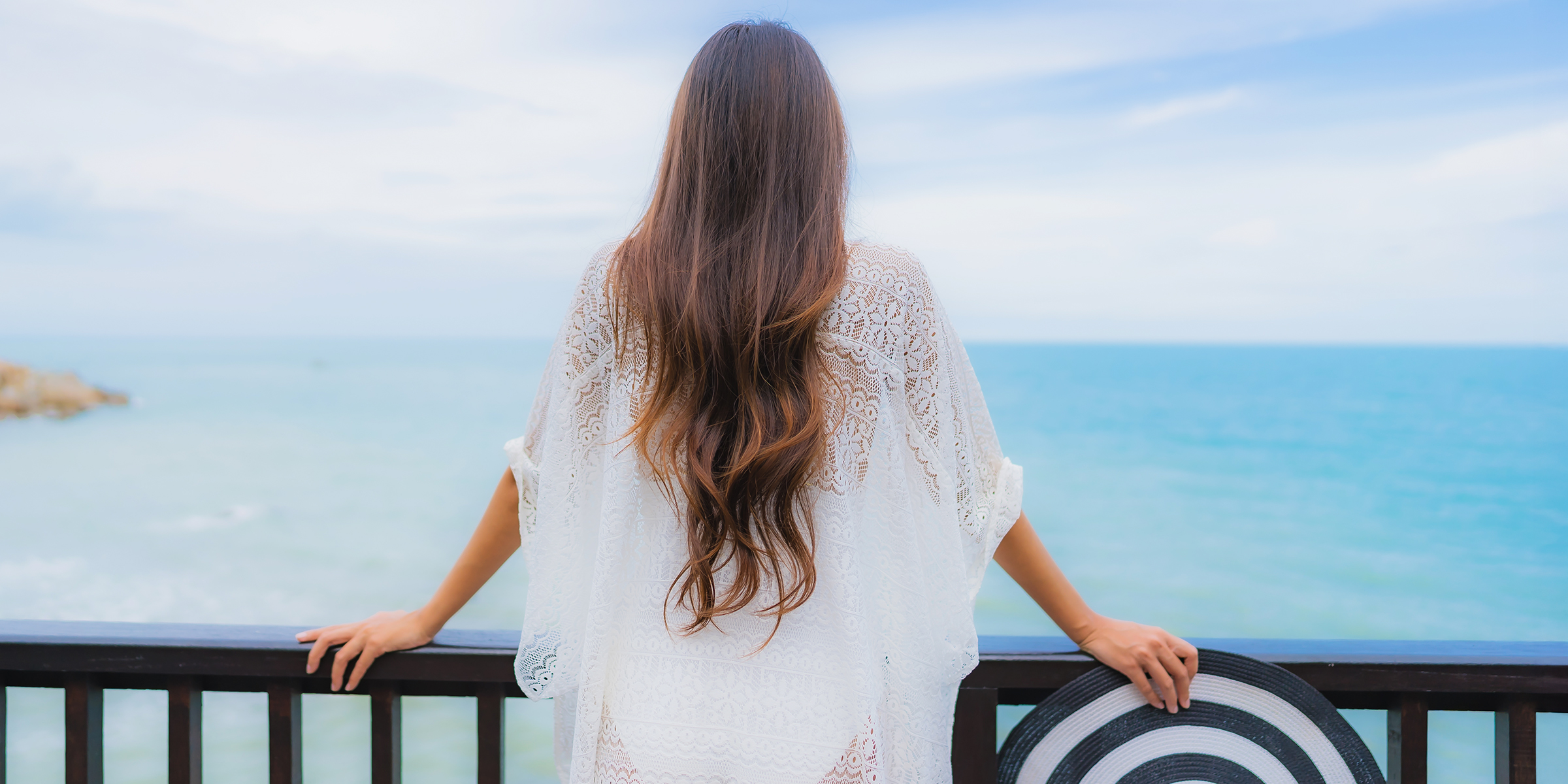 A woman looking at the ocean from a balcony | Source: Shutterstock