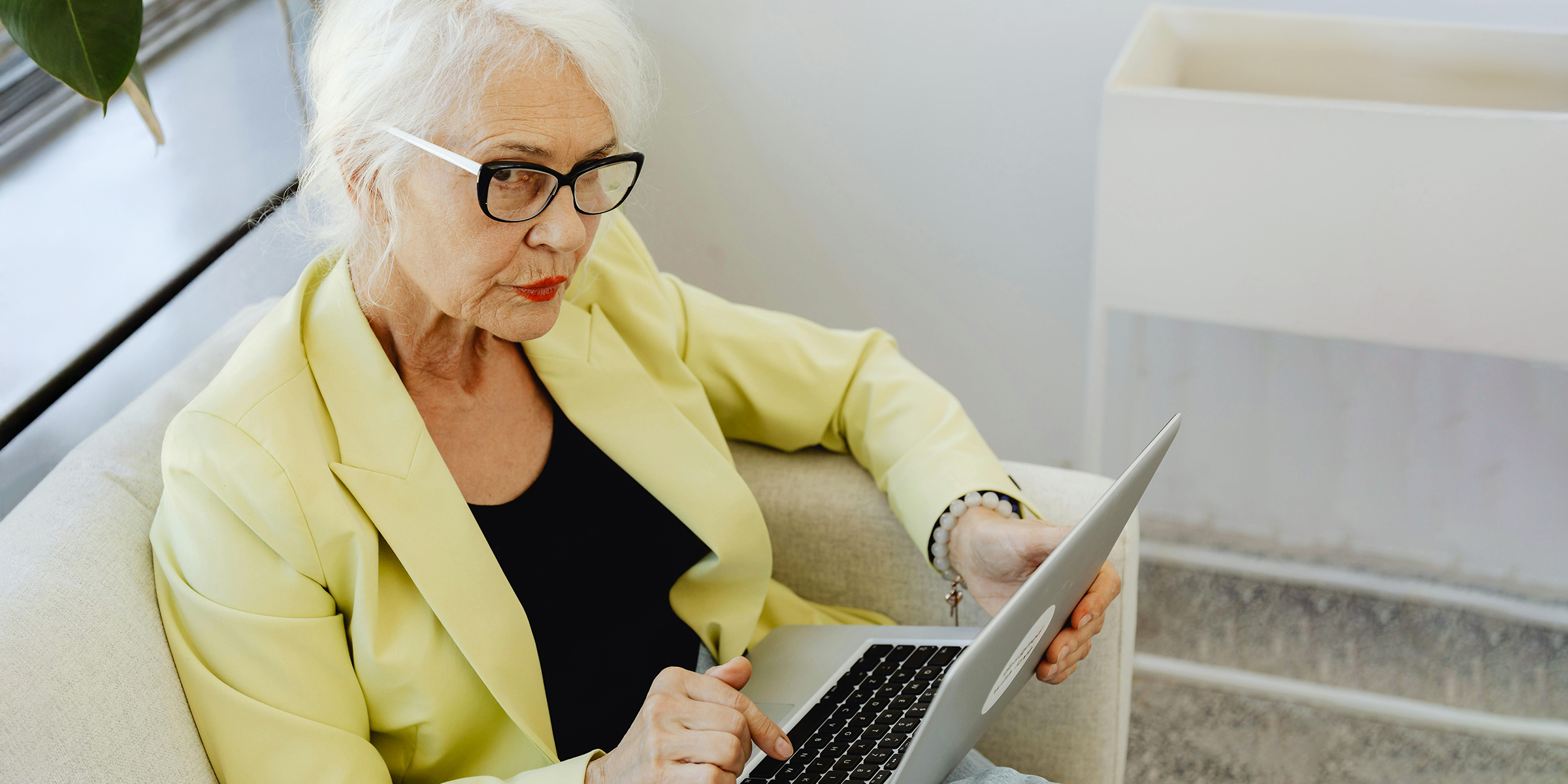 Thoughtful elderly woman working on her laptop | Source: Midjourney