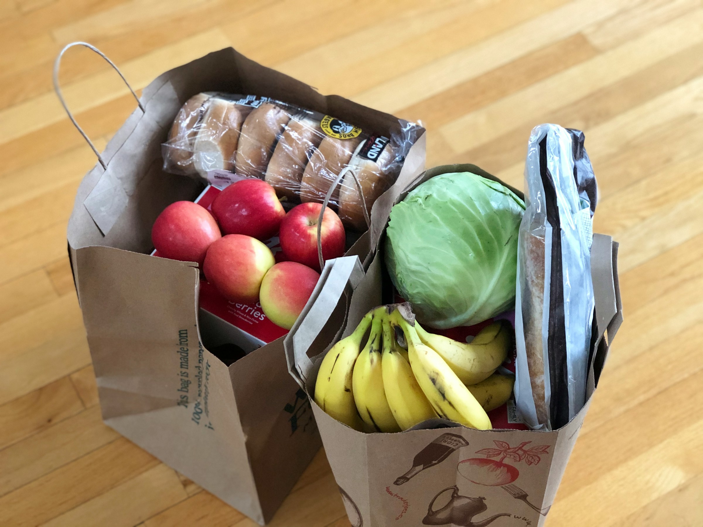 A photo of two grocery bags lying on a wooden surface | Source: Unsplash