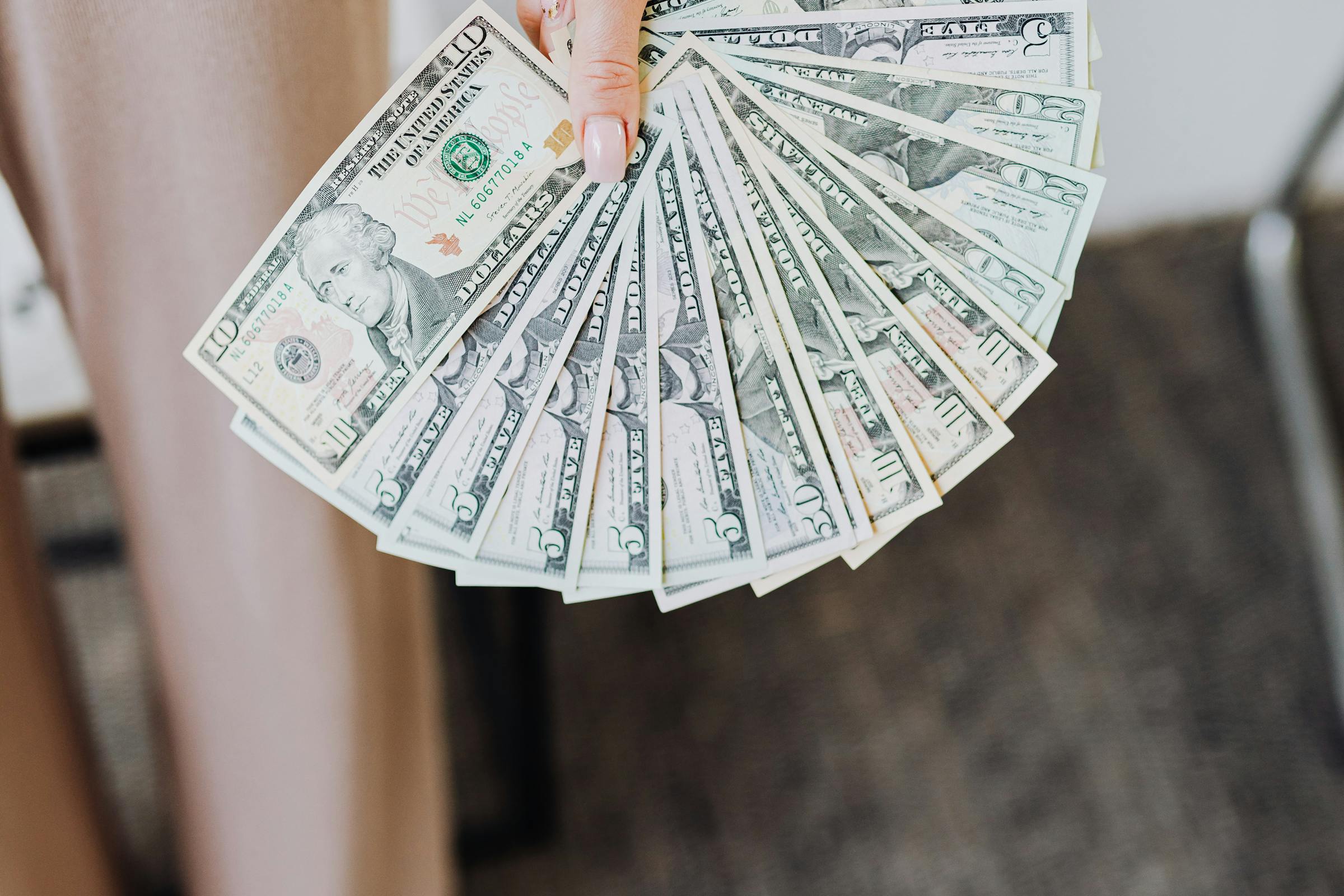 A woman handing over a wad of cash | Source: Pexels