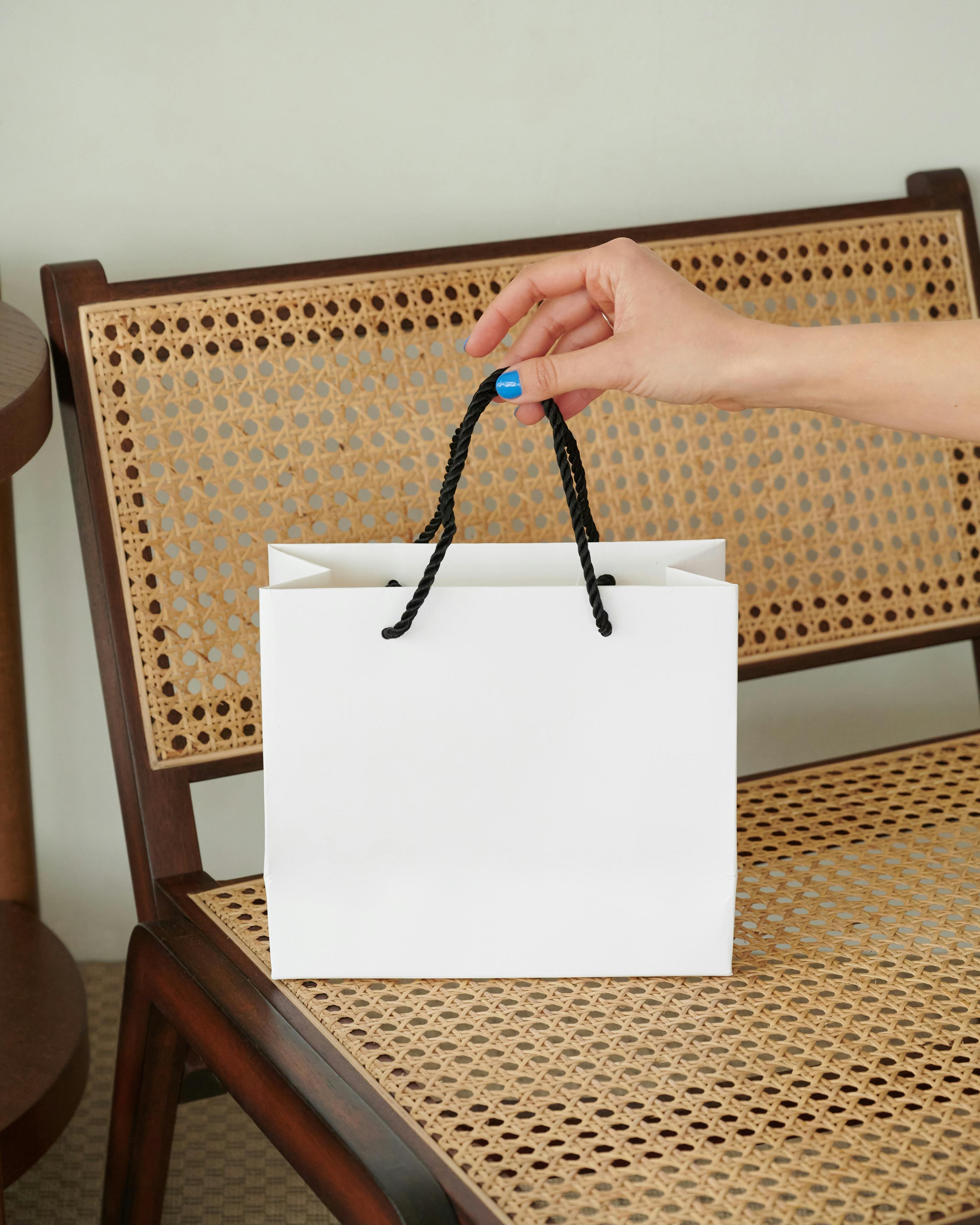 A person holding a white gift bag | Source: Pexels