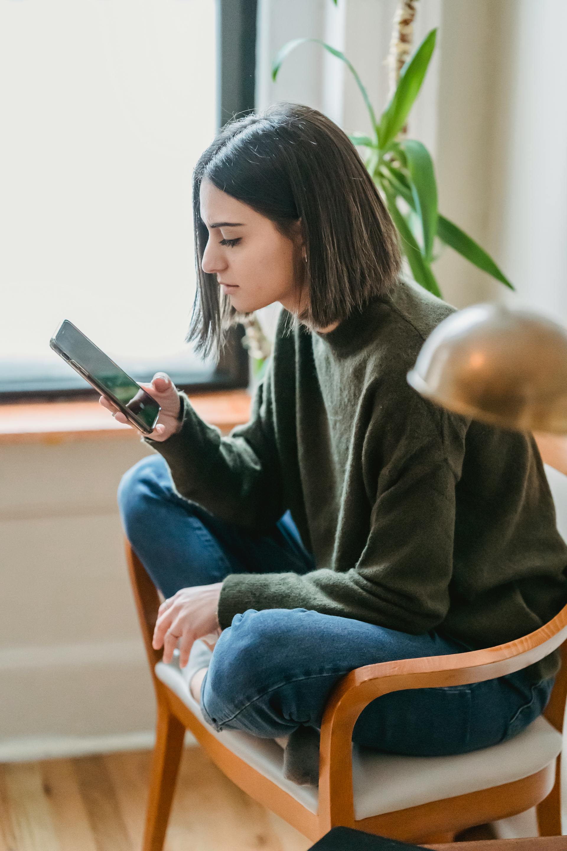 A woman holding her cell phone | Source: Pexels