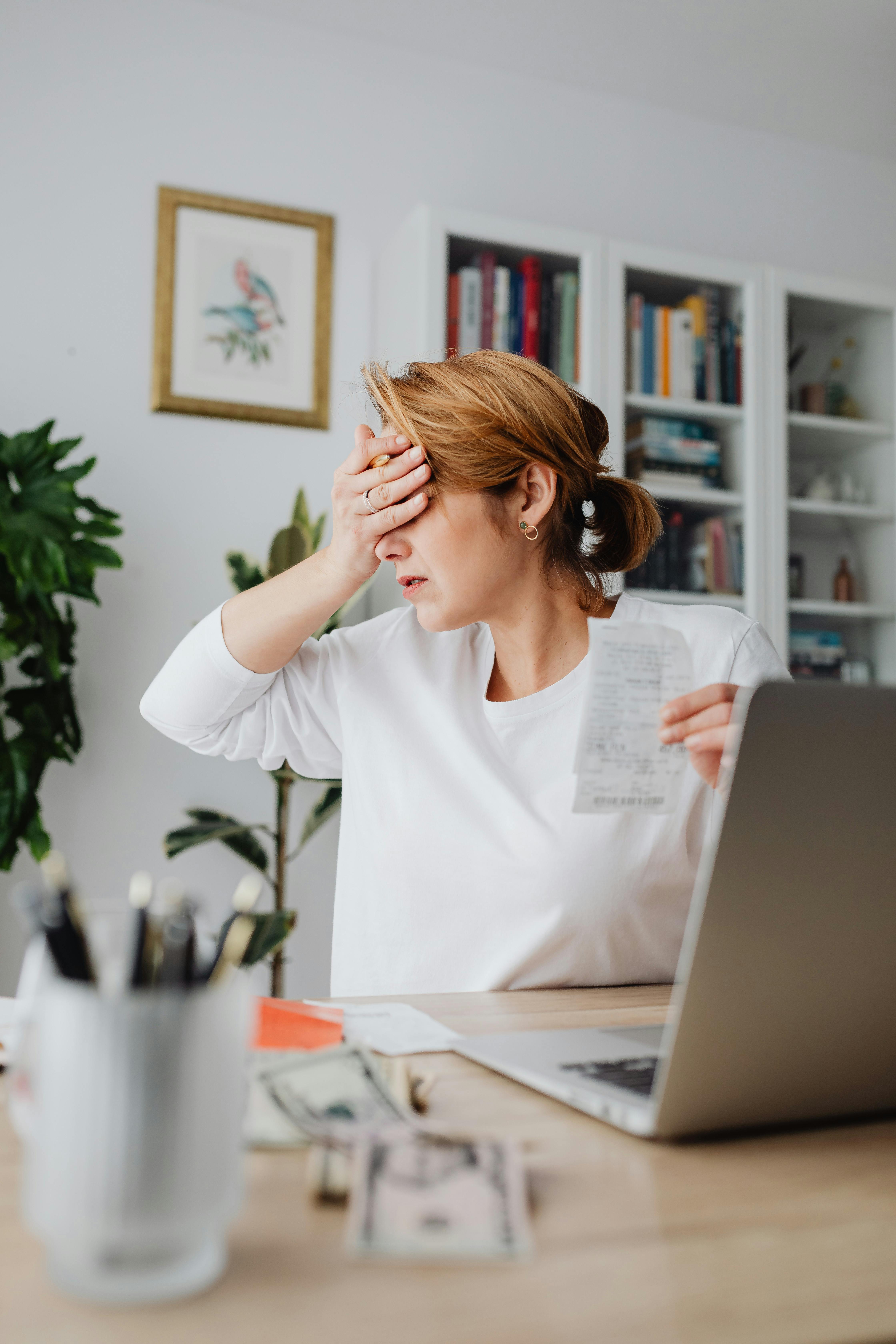 An upset woman holding a slip | Source: Pexels