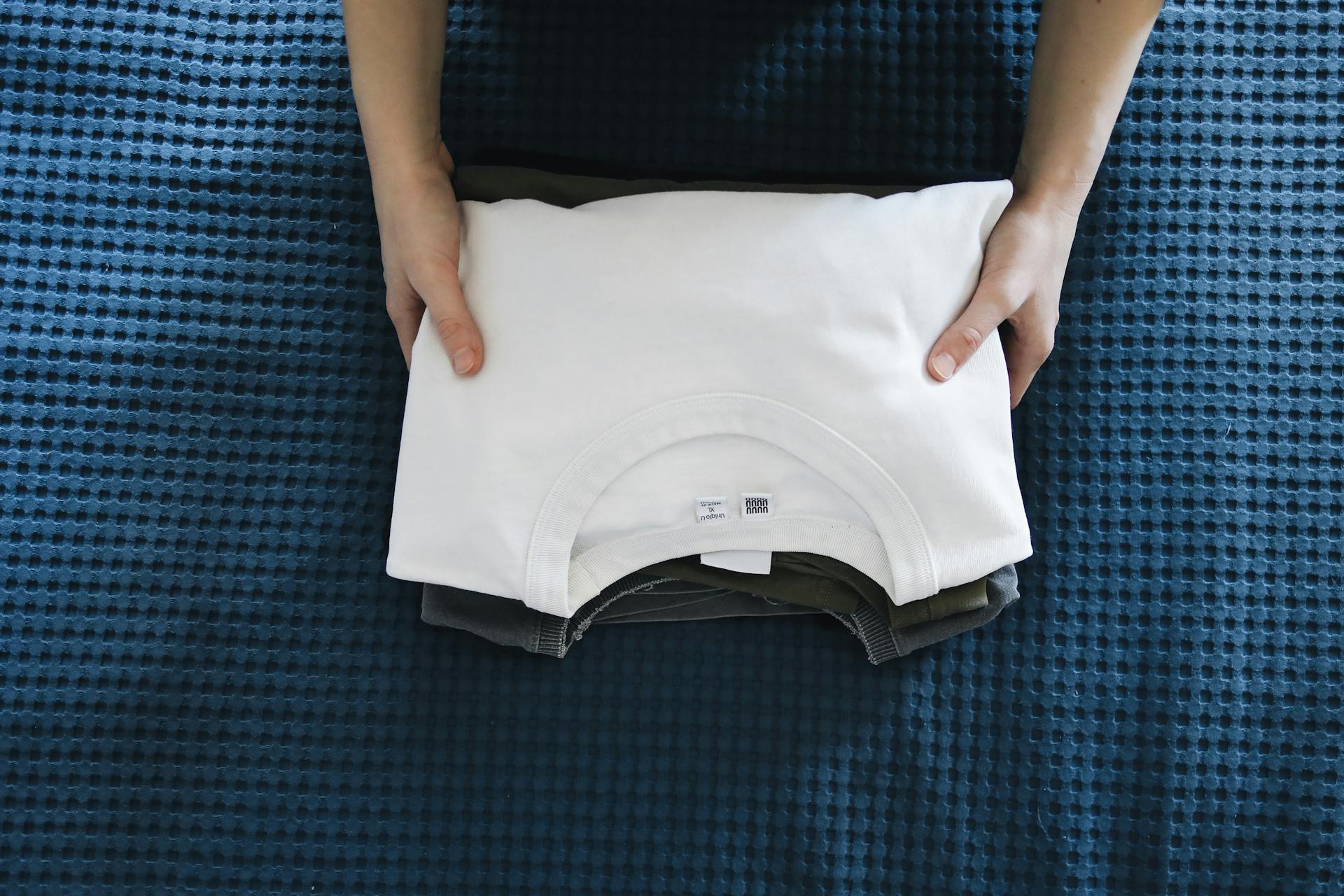 A person holding folded t shirts | Source: Pexels