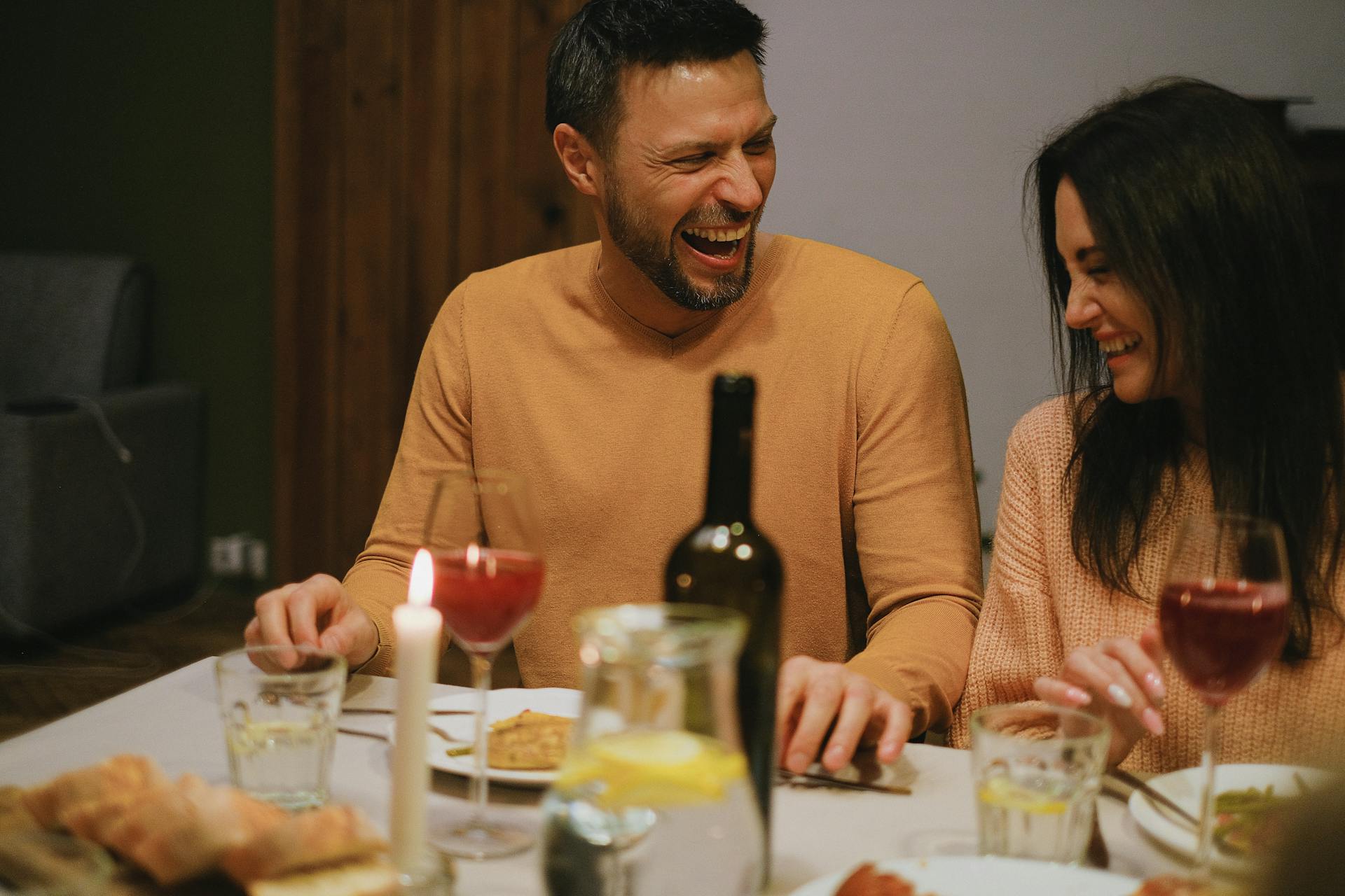 Two people laughing during dinner | Source: Pexels